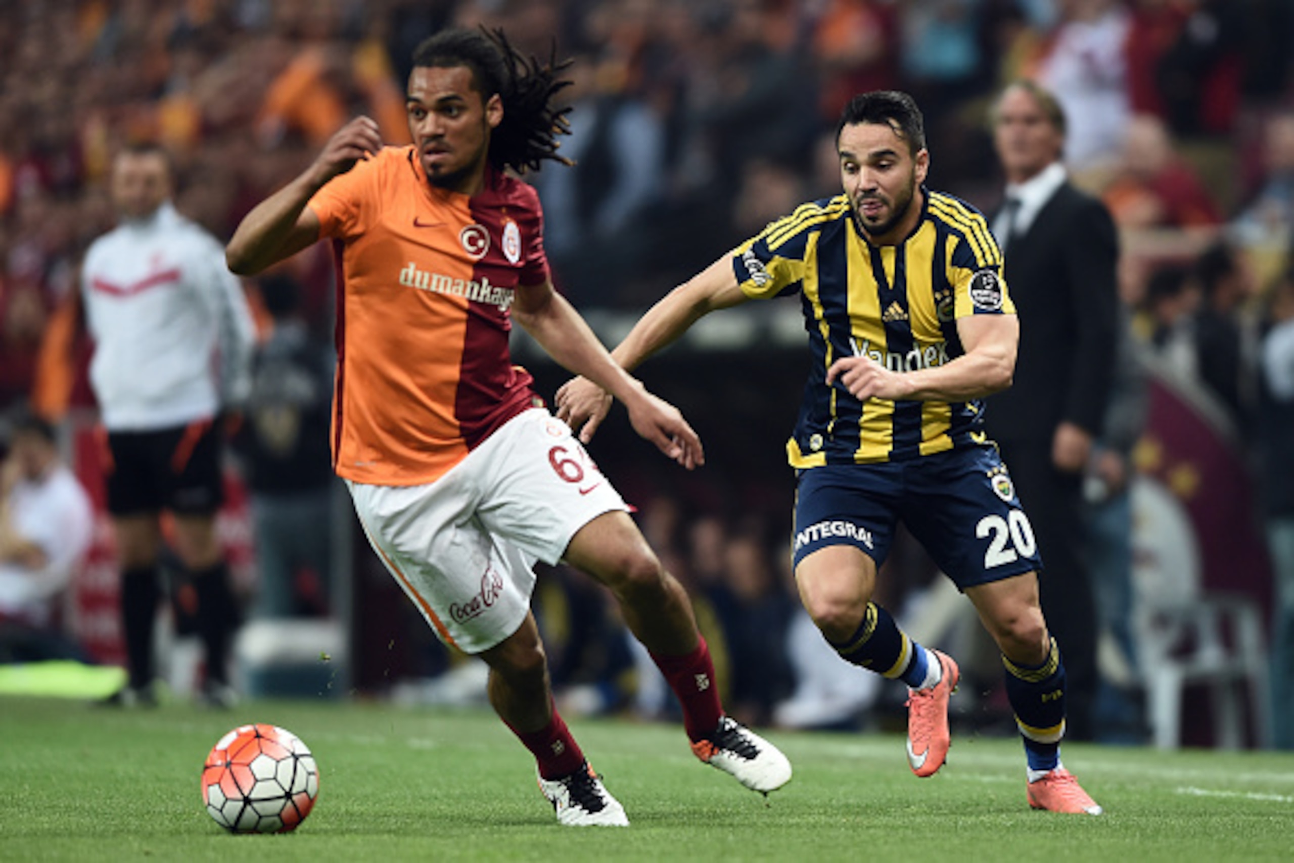 Fenerbahce`s Volkan Sen (R) vies for the ball with Galatasaray`s Jason Denayer (L) during the Turkish Spor Toto Super league football match between Galatasaray and Fenerbahce at TT arena stadium on April 13, 2016 in Istanbul. / AFP / OZAN KOSE        (Pho