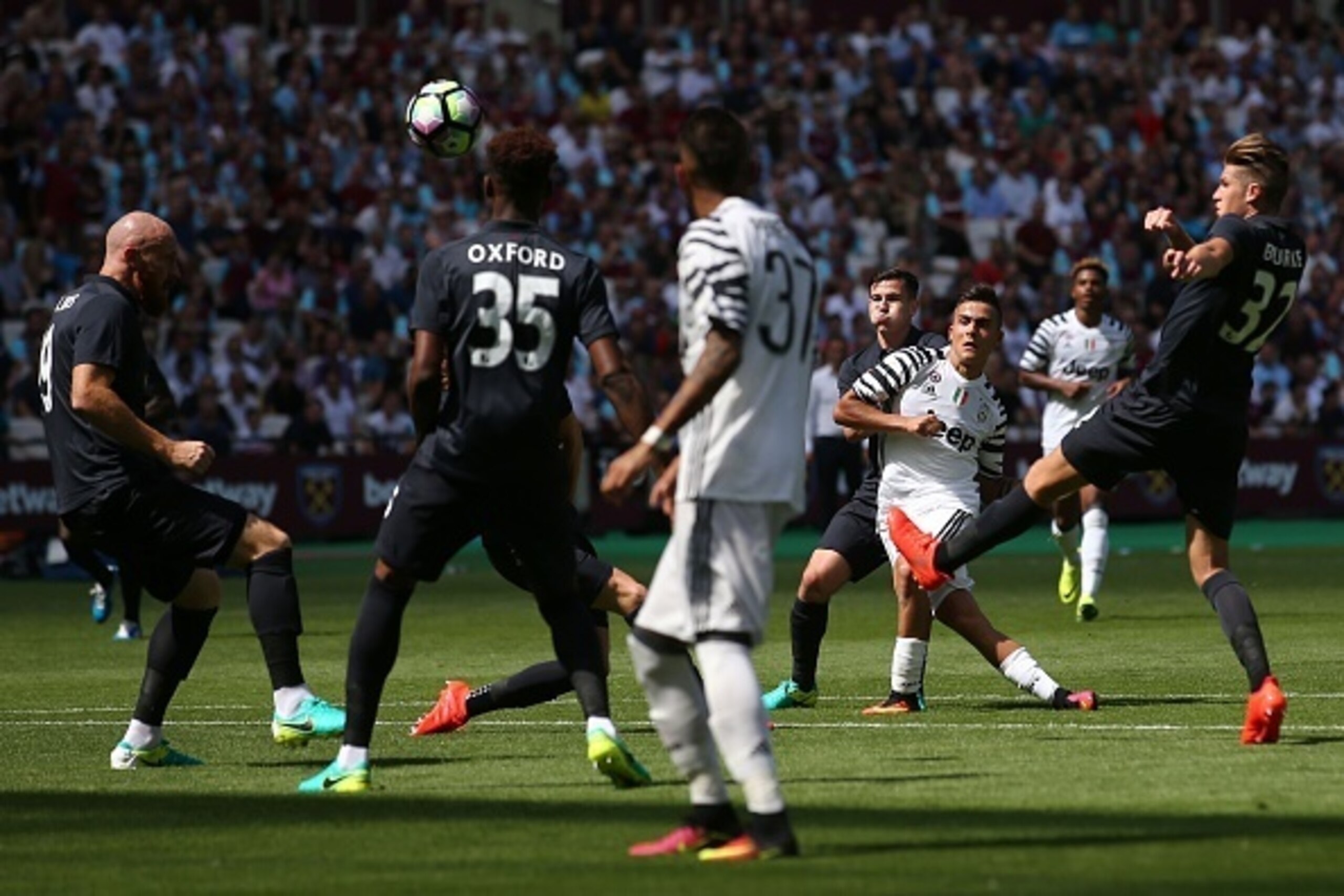 Juventus' Argentinian striker Paulo Dybala (2R) takes a shot that goes over the bar during the pre-season friendly football match between West Ham United and Juventus at the London Stadium in east London on August 7, 2016. / AFP / JUSTIN TALLIS        (Ph