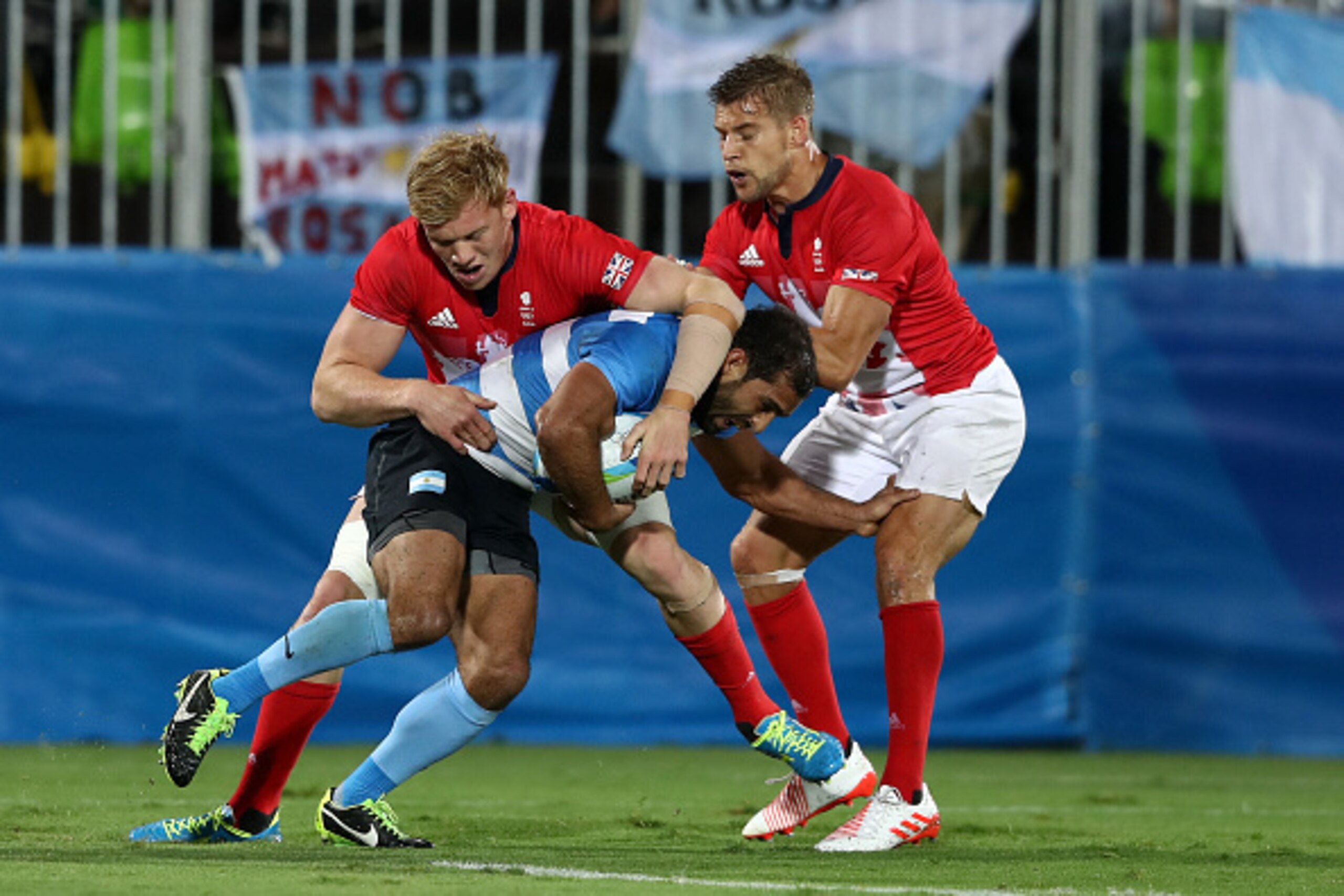 RIO DE JANEIRO, BRAZIL - AUGUST 10:  Gaston Revol of Argentina is tackled by Sam Cross and Tom Mitchell of Great Britain during the the Men's Quarter-final 3, Match 23 between Great Britain and Argentina on Day 5 of the Rio 2016 Olympic Games at Deodoro S