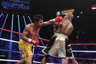Floyd Mayweather Jr. exchange punches with Manny Pacquiao during their welterweight unification championship bout, May 2, 2015 at MGM Grand Garden Arena in Las Vegas, Nevada.  Mayweather defeated Pacquiao by unanimous decision.  AFP PHOTO / JOHN GURZINKSI