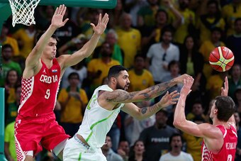 RIO DE JANEIRO, BRAZIL - AUGUST 11:  Augusto Lima #23 of Brazil passes the ball against Dario Saric #9 of Croatia and Mario Hezonja #8 of Croatia during the Men's Basketball - Preliminary Round Group B Brazil vs Croatia on Day 6 of the Rio 2016 Olympic Ga