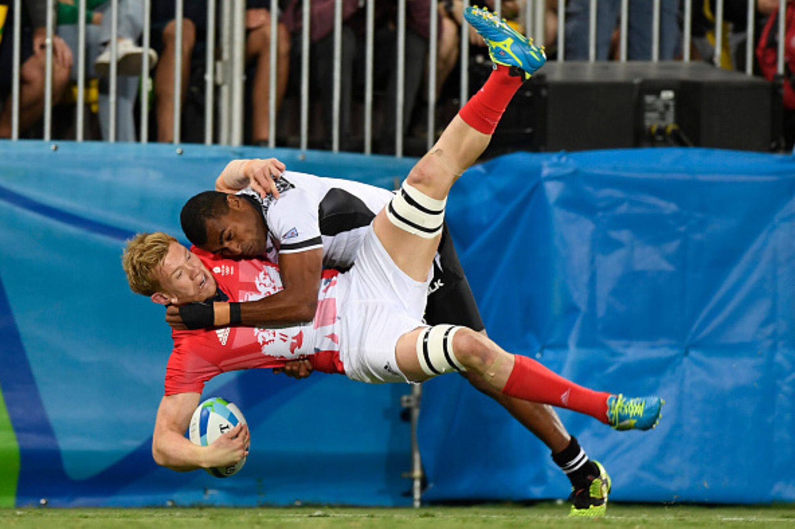 TOPSHOT - Britain's Mark Robertson (lower) is tackled by Fiji's Josua Tuisova in the mens rugby sevens gold medal match between Fiji and Britain during the Rio 2016 Olympic Games at Deodoro Stadium in Rio de Janeiro on August 11, 2016. / AFP / John MACDOU