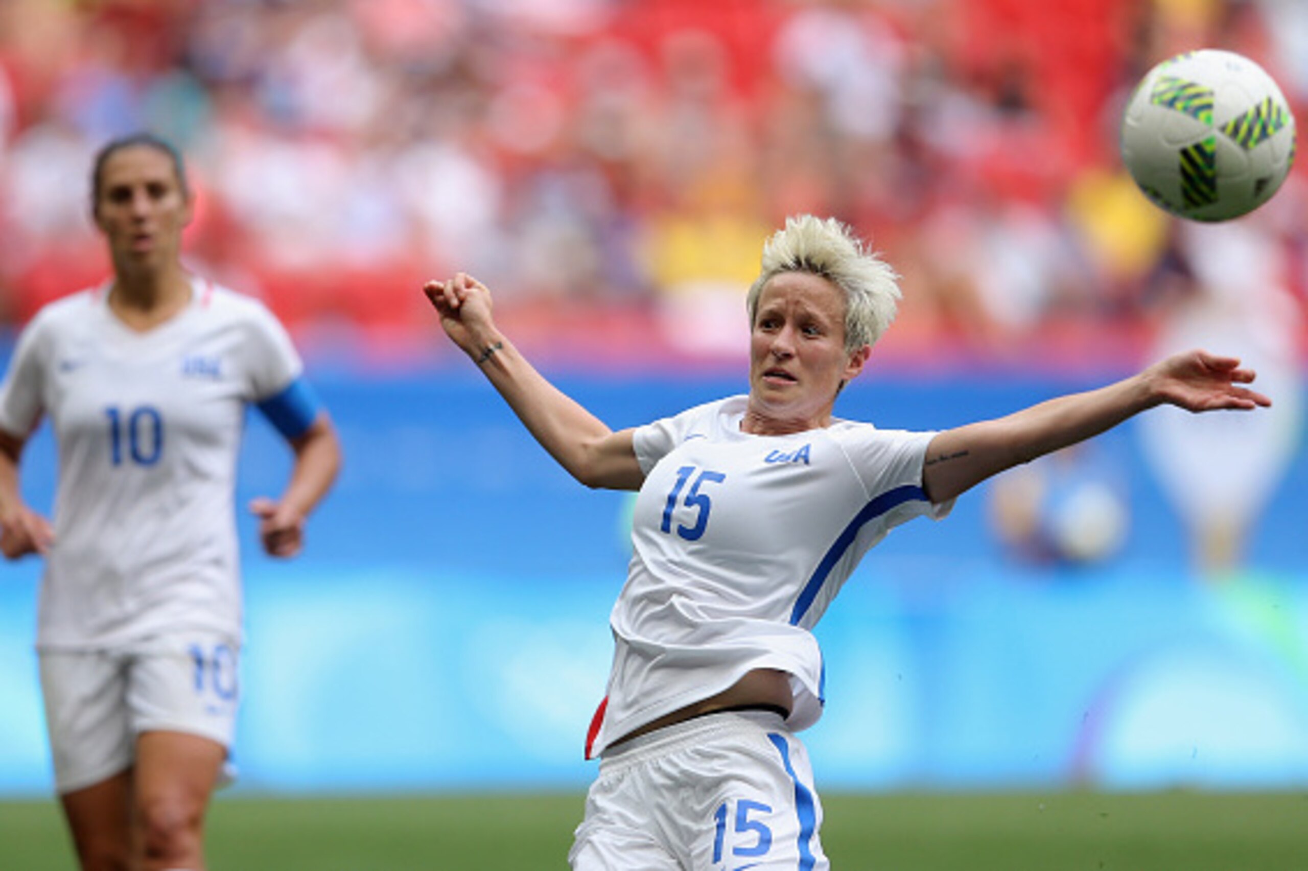 BRASILIA, BRAZIL - AUGUST 12:  Megan Rapinoe #15 of United States goes up for the ball against Sweden in the second half as Carli Lloyd #10 of United States looks on during the Women's Football Quarterfinal match at Mane Garrincha Stadium on Day 7 of the 