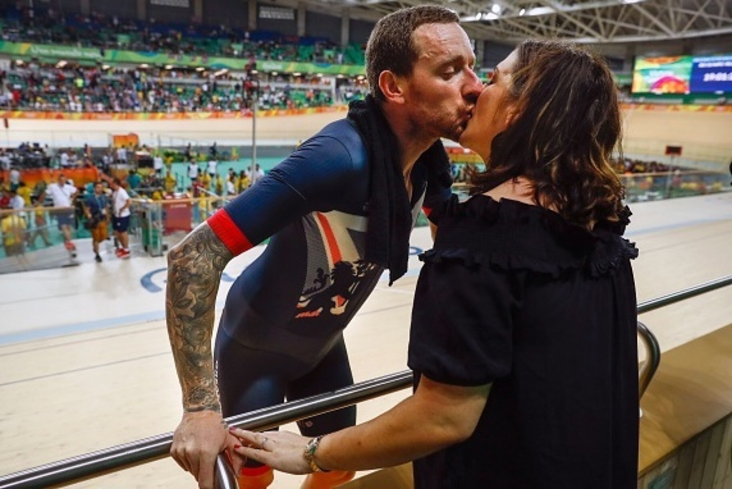 Britain's Bradley Wiggins (L) kisses his wife Catherine Wiggins after winning gold in the men's Team Pursuit finals track cycling event at the Velodrome during the Rio 2016 Olympic Games in Rio de Janeiro on August 12, 2016. / AFP / Odd ANDERSEN        (P