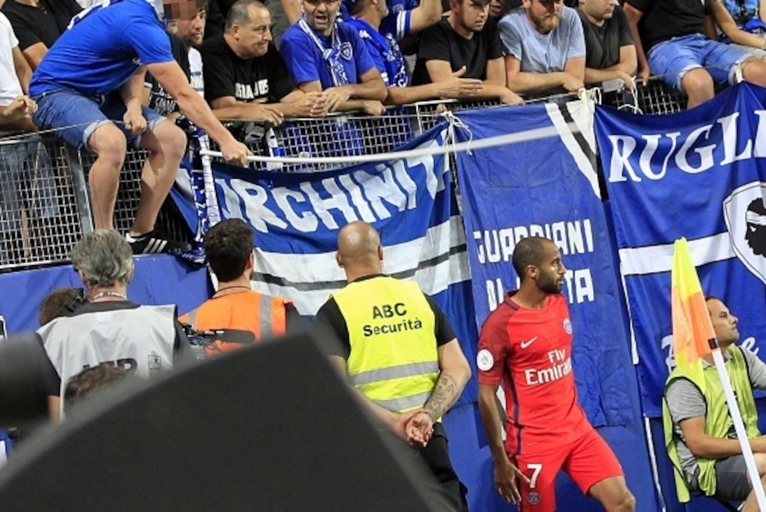 A Bastia's supporter (L) tries to hit Paris Saint-Germain's Brazilian midfielder Lucas Moura (R) with a stick from the stands during the French Ligue 1 football match between  Bastia (SCB) and Paris Saint Germain (PSG) on August 12, 2016 at the Armand Ces