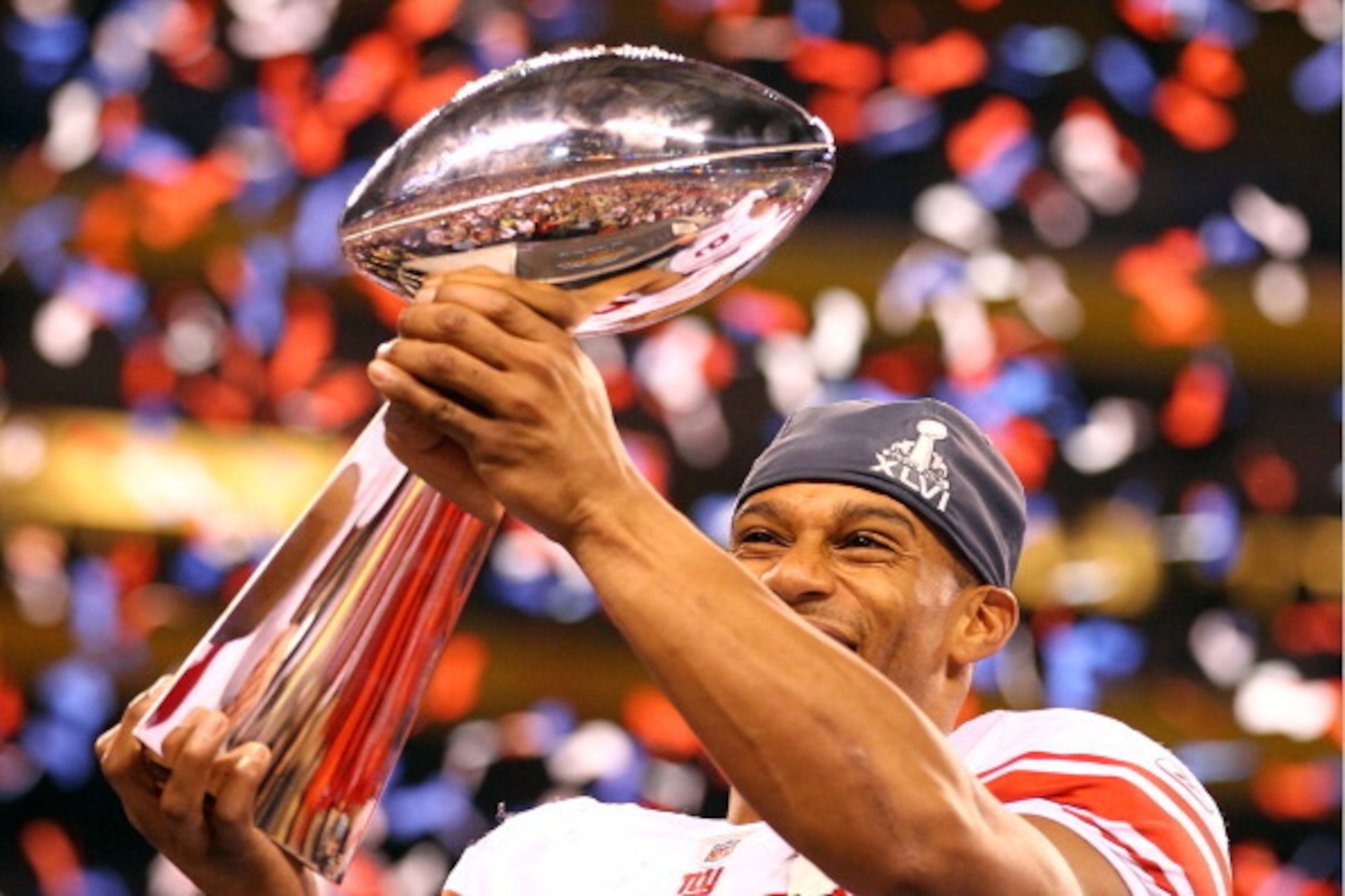 INDIANAPOLIS, IN - FEBRUARY 05:  Victor Cruz #80 of the New York Giants hoist the Vince Lombardi Trophy after defeating the New England Patriots in Super Bowl XLVI at Lucas Oil Stadium on February 5, 2012 in Indianapolis, Indiana. The New York Giants defe