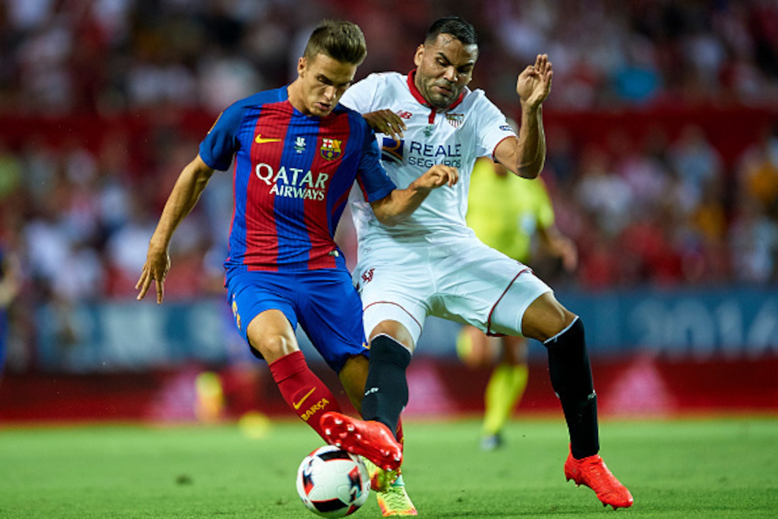 SEVILLE, SPAIN - AUGUST 14:  Denis Suarez of FC Barcelona (L) is challenged by Gabriel Mercado of Sevilla FC (R) during the match between Sevilla FC vs FC Barcelona as part of the Spanish Super Cup Final 1st Leg  at Estadio Ramon Sanchez Pizjuan on August