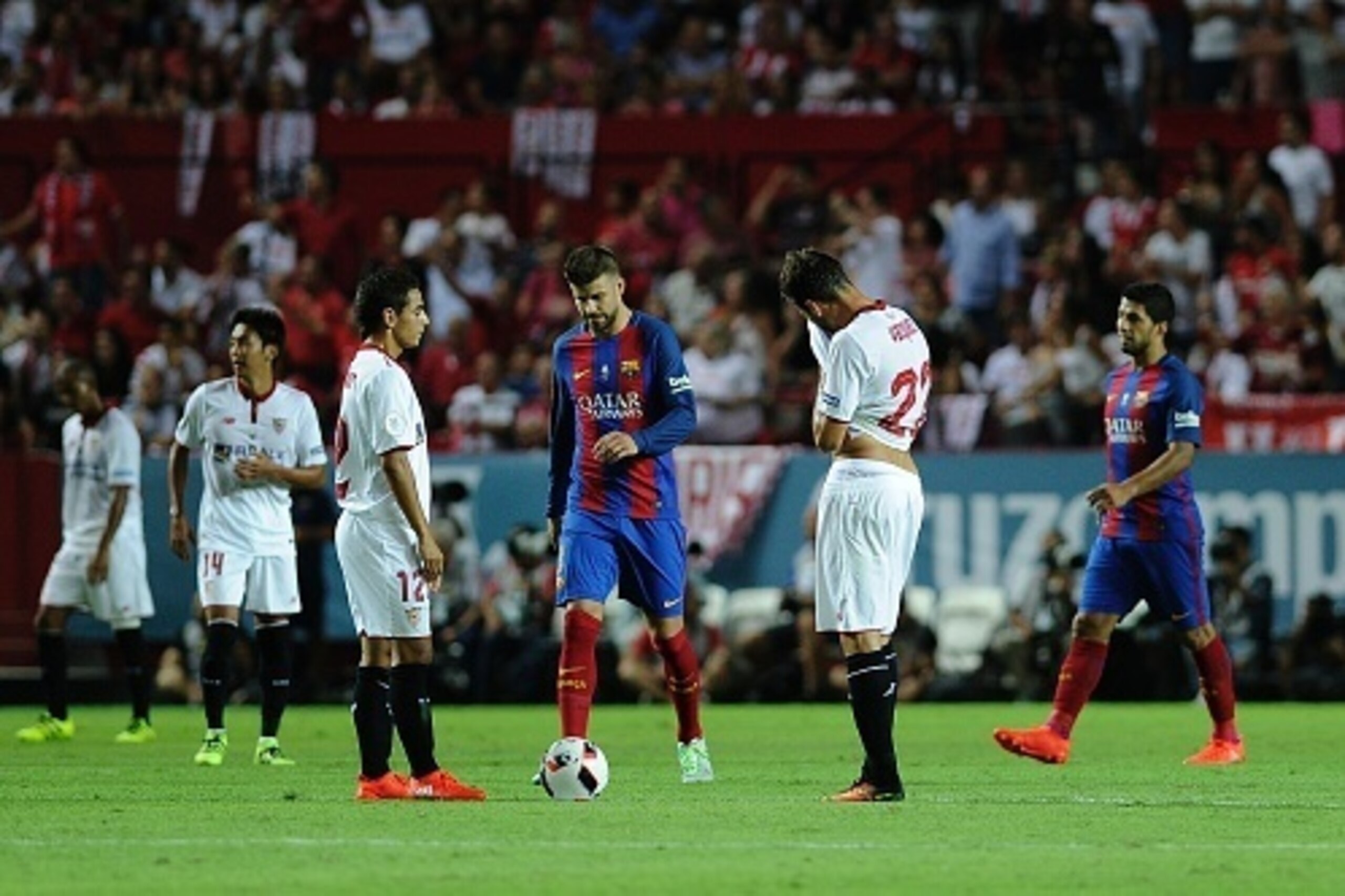 Sevilla's players react after Barcelona's forward Munir El Haddadi scored a goal during the first leg of the Spanish Supercup football match between Sevilla FC and FC Barcelona at the Ramon Sanchez Pizjuan stadium in Sevilla on August 14, 2016. / AFP / CR