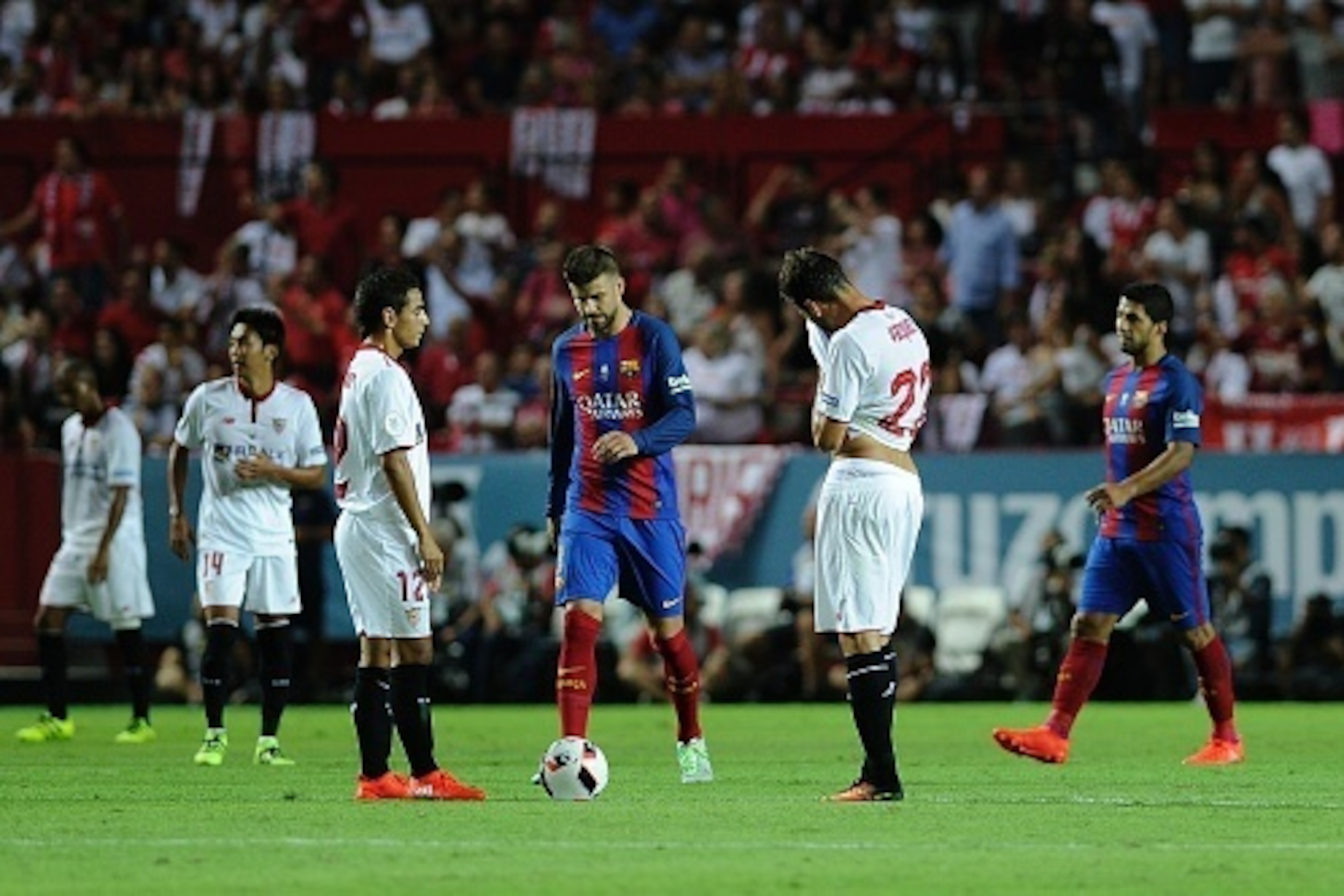 Sevilla's players react after Barcelona's forward Munir El Haddadi scored a goal during the first leg of the Spanish Supercup football match between Sevilla FC and FC Barcelona at the Ramon Sanchez Pizjuan stadium in Sevilla on August 14, 2016. / AFP / CR