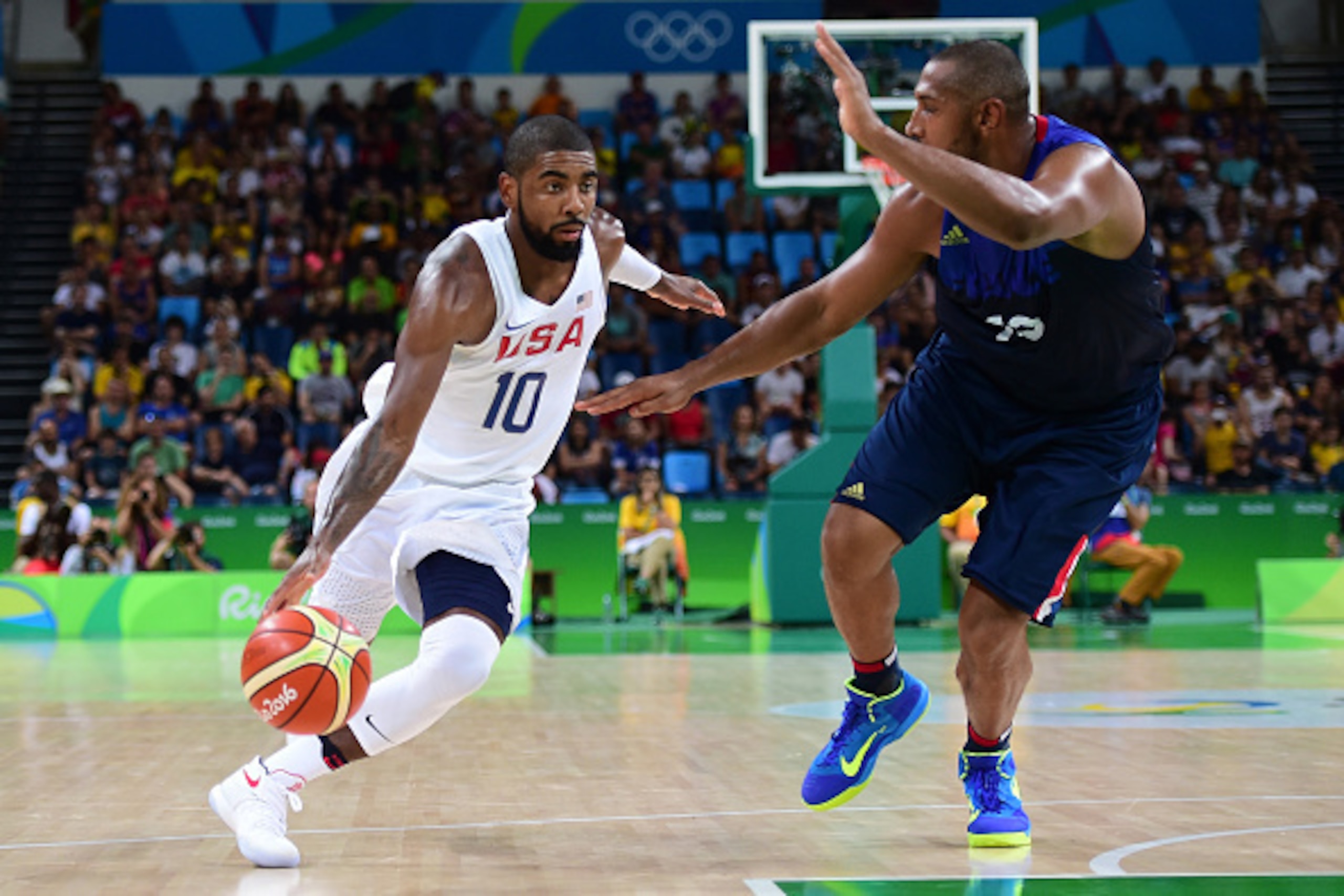 RIO DE JANEIRO, BRAZIL - AUGUST 14:  Kyrie Irving #10 of United States moves the ball against Boris Diaw #13 of France during a Men's Preliminary Round Group A game between the United States and France on Day 9 of the Rio 2016 Olympic Games at Carioca Are