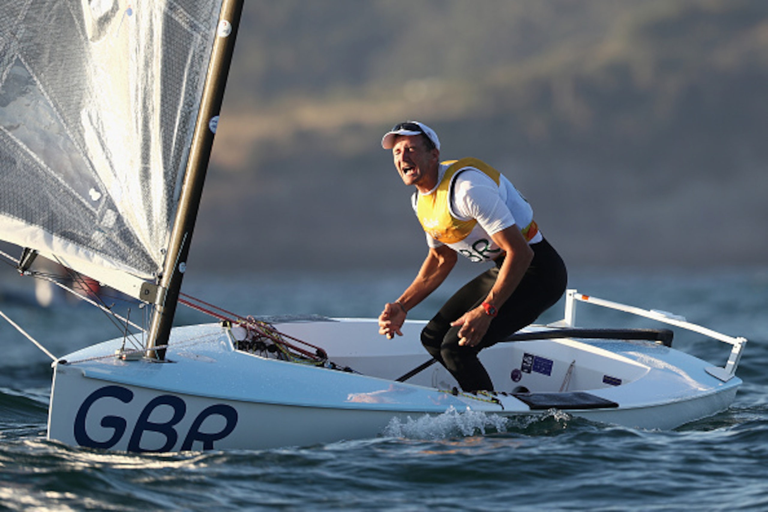 RIO DE JANEIRO, BRAZIL - AUGUST 14:  Giles Scott of Great Britain celebrates clinching a gold medal after his second Finn Class race on Day 9 of the Rio 2016 Olympic Games at the Marina da Gloria on August 14, 2016 in Rio de Janeiro, Brazil.  (Photo by Cl