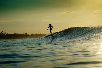 A longboarder rides a wave at the Praia da Macumba beach on August 5, 2016 in Rio de Janeiro on the day of the opening ceremony of the Rio 2016 Olympic Games. 
Surfing will become an Olympic discipline for next Olympic Games in Tokyo in 2020. / AFP / OLIV