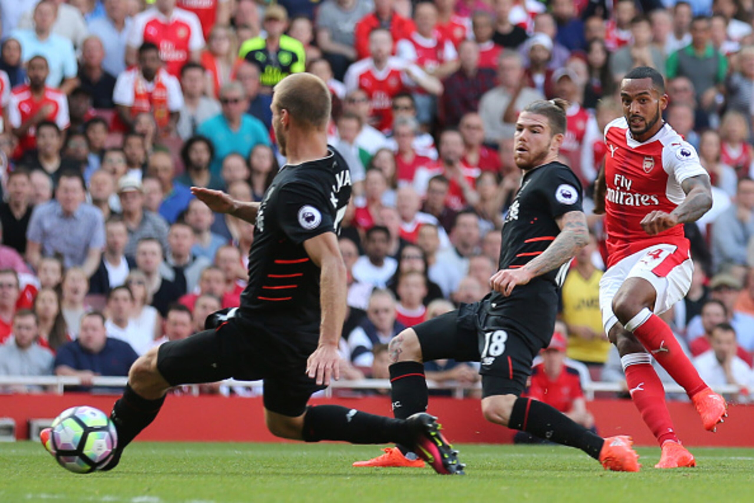 Arsenal's English midfielder Theo Walcott (R) scores the opening goal during the English Premier League football match between Arsenal and Liverpool at the Emirates Stadium in London on August 14, 2016.  / AFP / Lee MILLS / RESTRICTED TO EDITORIAL USE. No