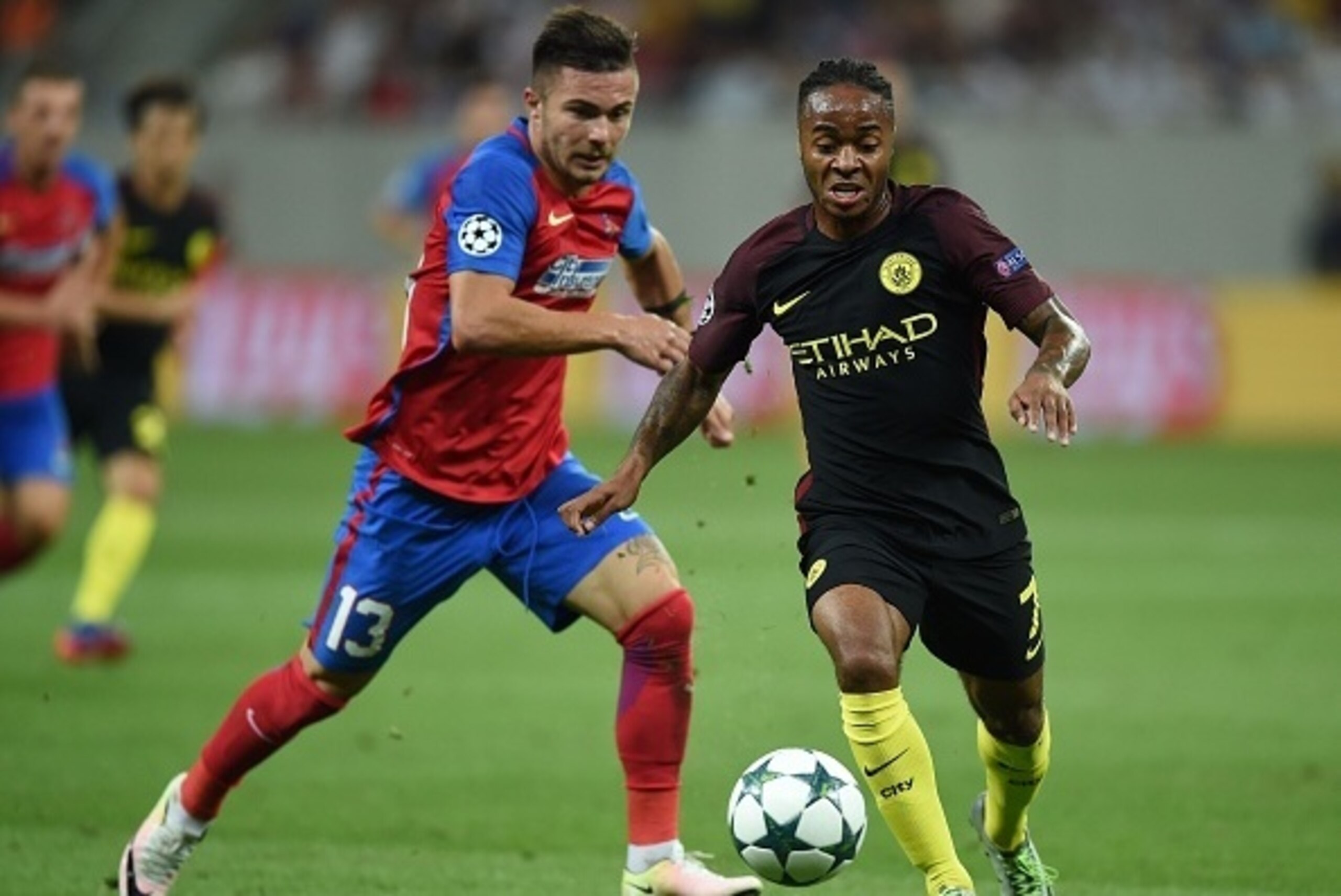 Manchester City's English midfielder Raheem Sterling (R) vies for the ball with Steaua Bucharest's Romanian defender Alin Tosca during the UEFA Champions league first leg play-off football match between Steaua Bucharest and Manchester City at the National