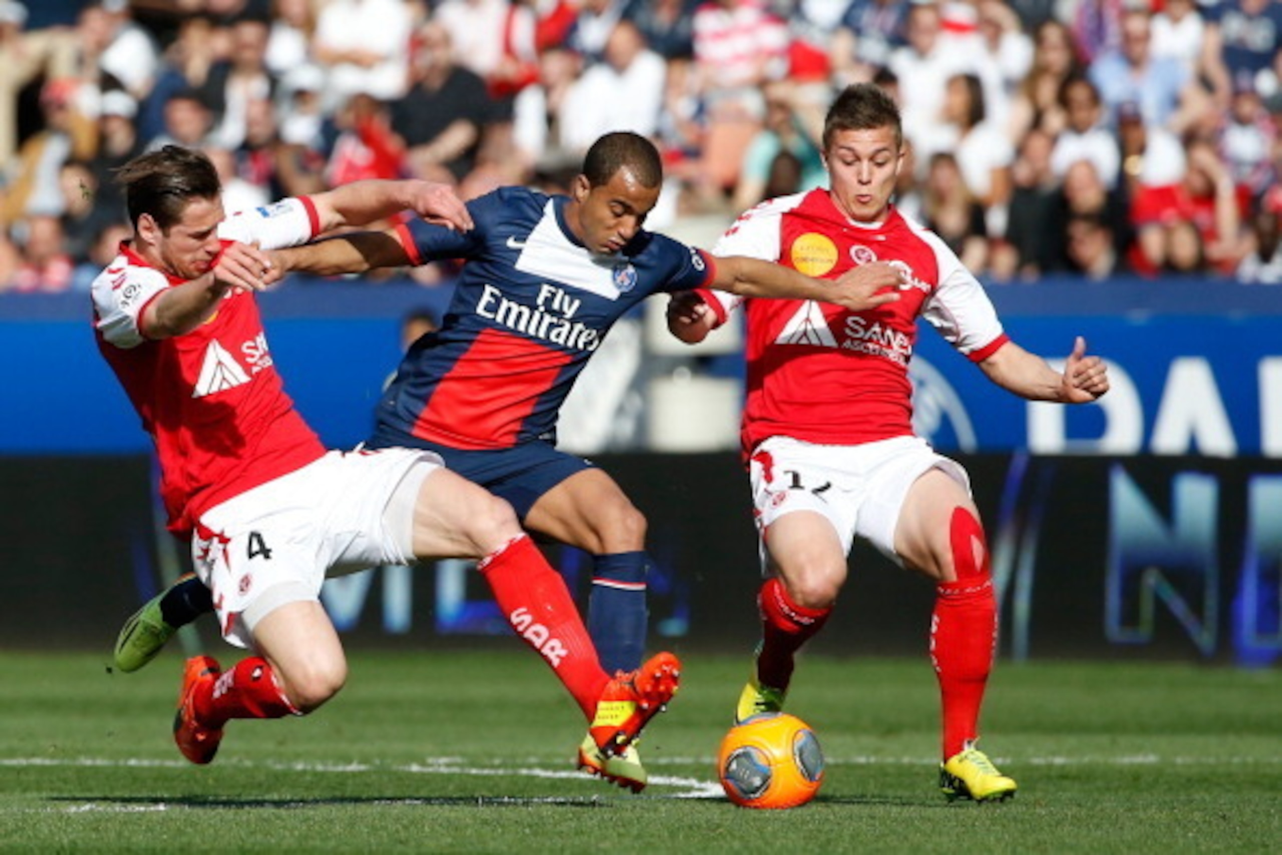 Paris' Brazilian forward Lucas Moura (C) vies with Reims' midfielder Grzegorz Krychowiak (L) and Reims' forward Nicolas de Préville during the French L1 football match Paris Saint-Germain vs Reims at the Parc des Princes stadium in Paris on April 5, 2014.