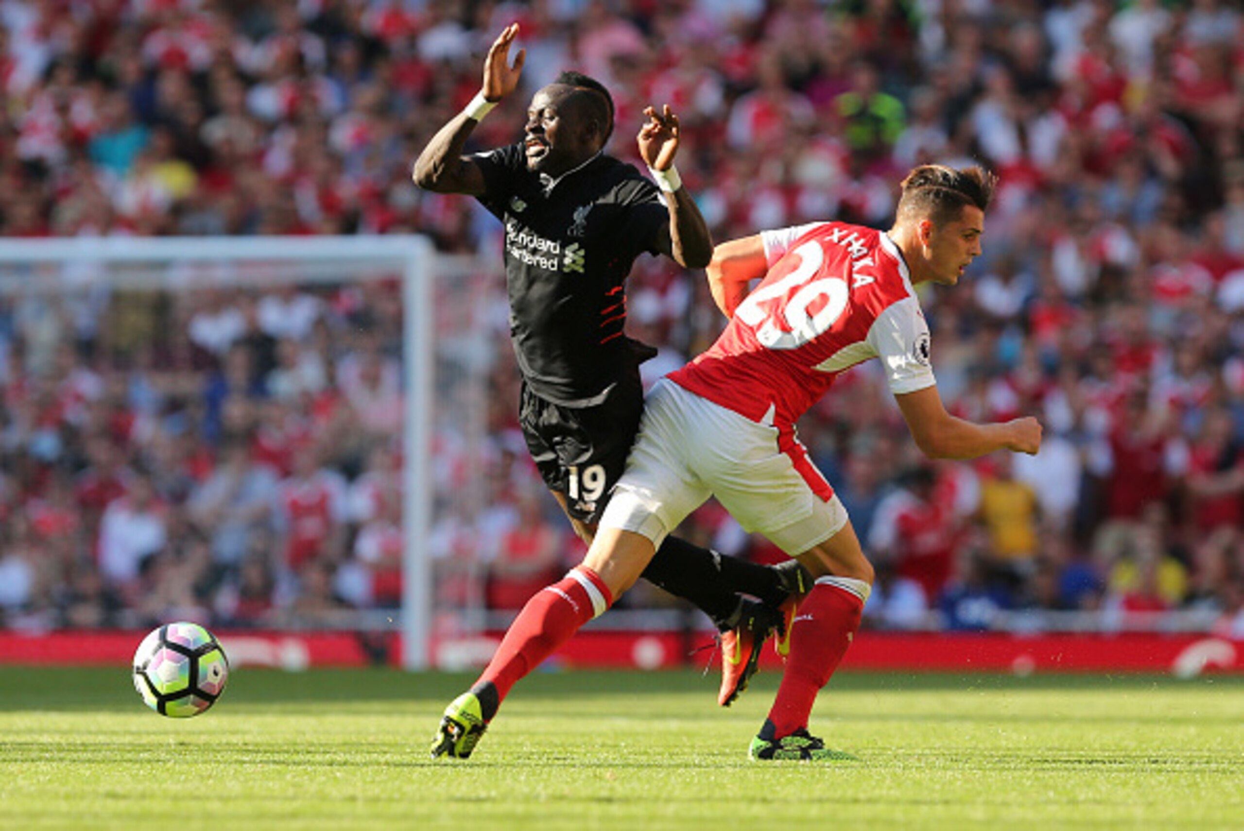 Arsenal's Swiss midfielder Granit Xhaka (R) challenges Liverpool's Senegalese midfielder Sadio Mane (L) during the English Premier League football match between Arsenal and Liverpool at the Emirates Stadium in London on August 14, 2016.  / AFP / Lee MILLS