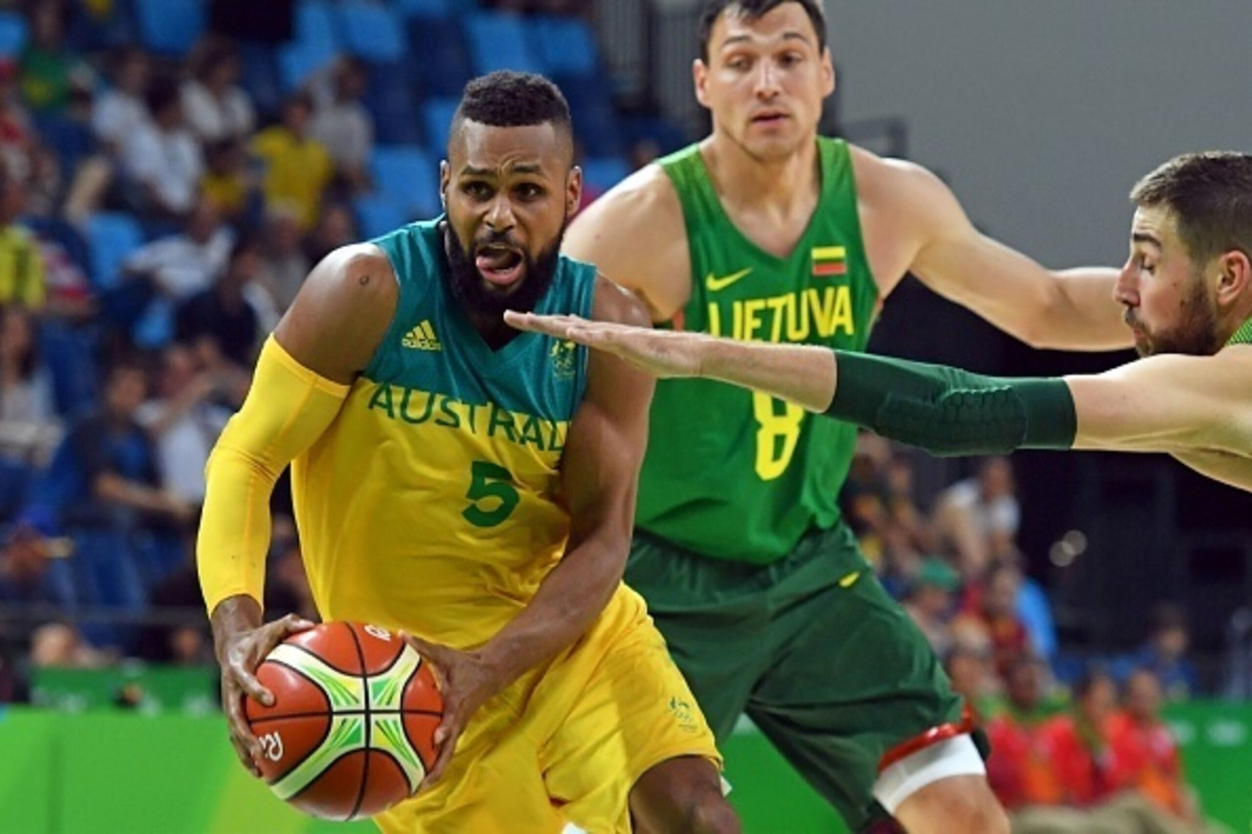 Australia's guard Patty Mills (L) evades Lithuania's small forward Jonas Maciulis (Rear) and Lithuania's centre Jonas Valanciunas during a Men's quarterfinal basketball match between Australia and Lithuania at the Carioca Arena 1 in Rio de Janeiro on Augu