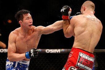 SINGAPORE - JANUARY 04:  (L-R) Lim Hyun Gyu punches Tarec Saffiedine in their welterweight bout during the UFC Fight Night event at the Marina Bay Sands Resort on January 4, 2014 in Singapore. (Photo by Josh Hedges/Zuffa LLC/Zuffa LLC via Getty Images)