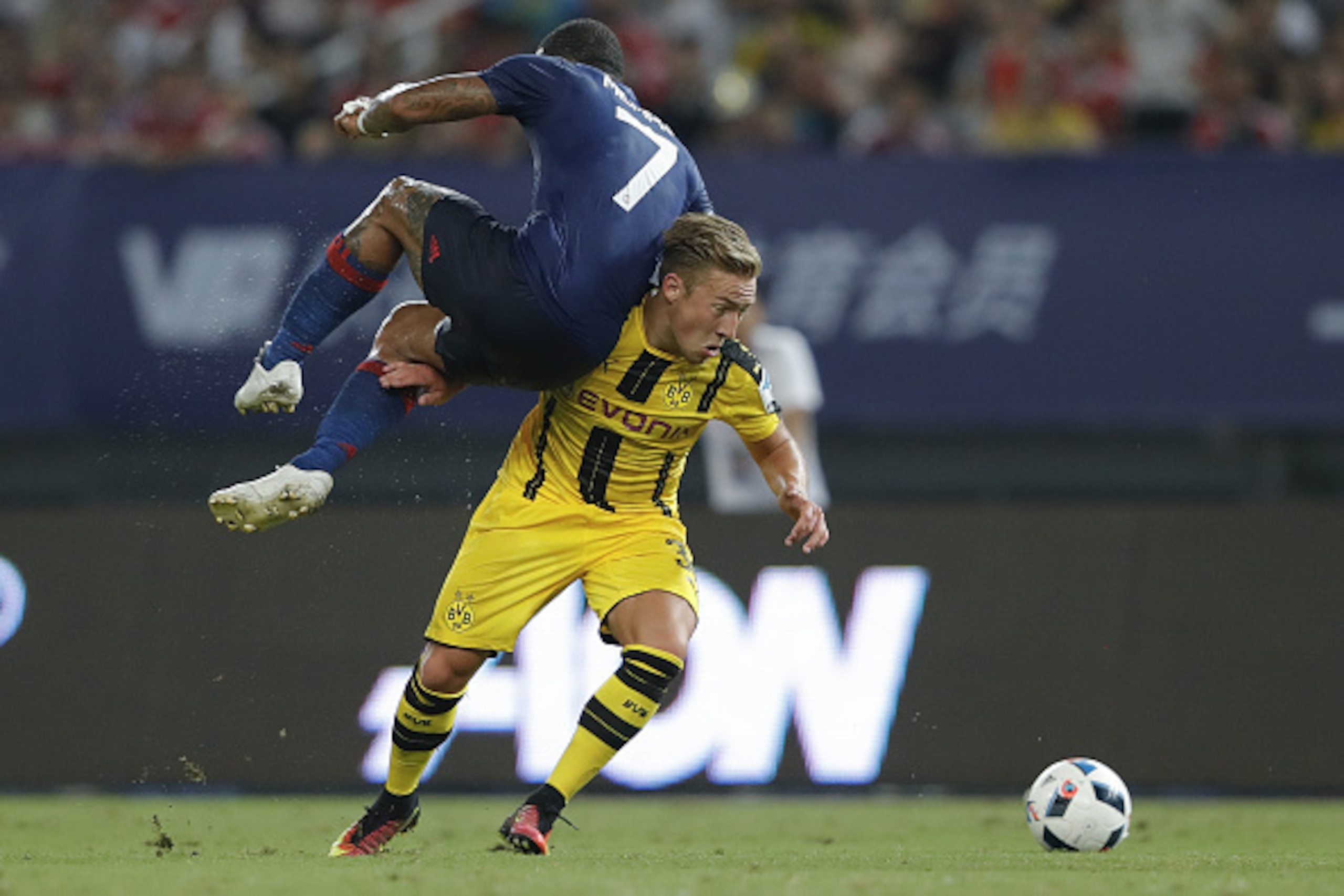 SHANGHAI, CHINA - JULY 22: Memphis Depay (L) of Manchester United competes for the ball with Felix Passlack of Borussia Dortmund during the International Champions Cup match between Manchester United and Borussia Dortmund at Shanghai Stadium on July 22, SHANGHAI, CHINA - JULY 22: Memphis Depay (L) of Manchester United competes for the ball with Felix Passlack of Borussia Dortmund during the International Champions Cup match between Manchester United and Borussia Dortmund at Shanghai Stadium on July 22,