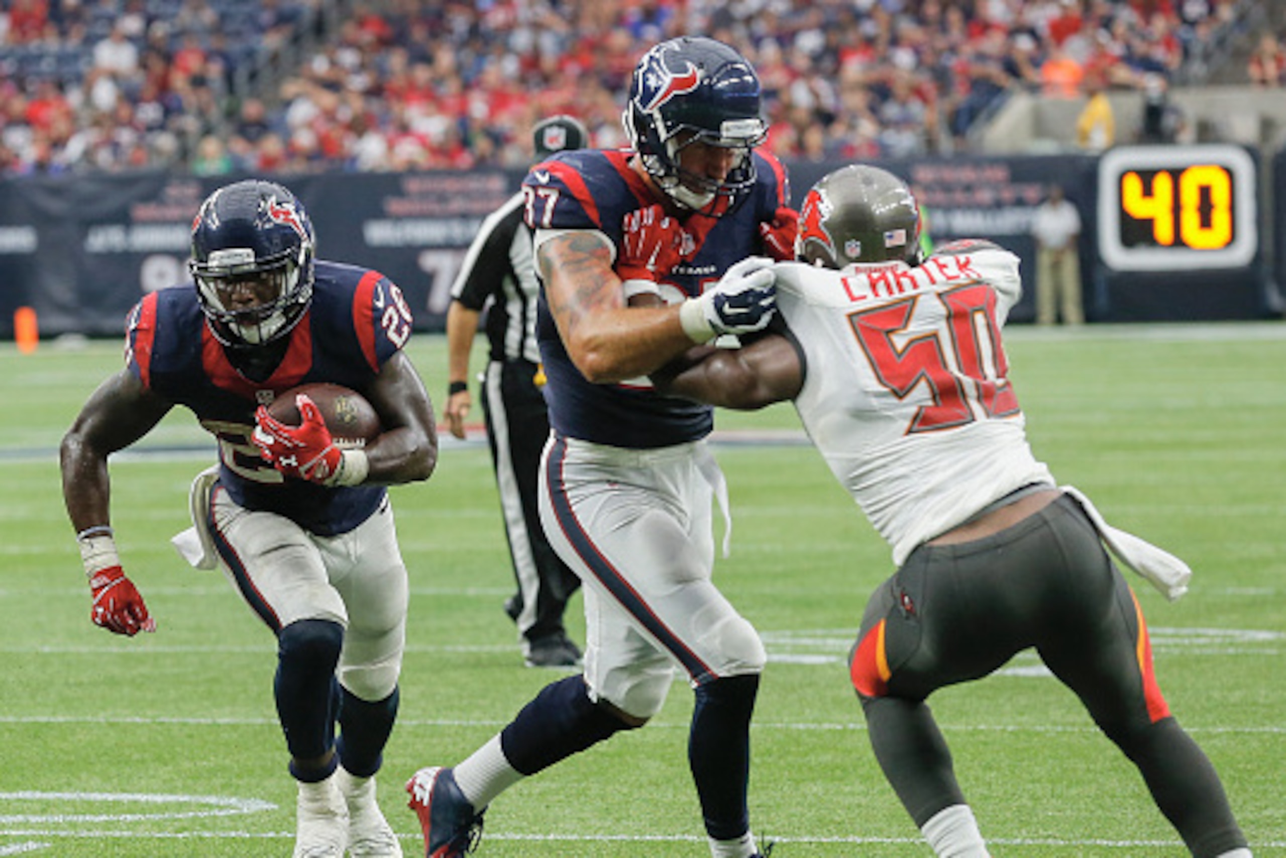 HOUSTON, TX - SEPTEMBER 27:  Alfred Blue #28 of the Houston Texans rushes as he receives a block from C.J. Fiedorowicz #87 on Bruce Carter #50 of the Tampa Bay Buccaneers at NRG Stadium on September 27, 2015 in Houston, Texas.  (Photo by Bob Levey/Getty I