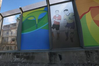 RIO DE JANEIRO, BRAZIL - JULY 18:  A 'sound barrier' with posters advertising the Olympics is attached along a stretch of the main highway which links Rio's international airport to the city center and tourist areas running above the Mare favela community