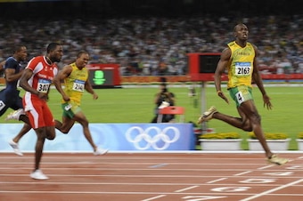 YEAR-2008 Jamaica's Usain Bolt (R) wins the men's 100m final at the National stadium as part of the 2008 Beijing Olympic Games on August 16, 2008.     AFP PHOTO / FABRICE COFFRINI (Photo credit should read FABRICE COFFRINI/AFP/Getty Images)