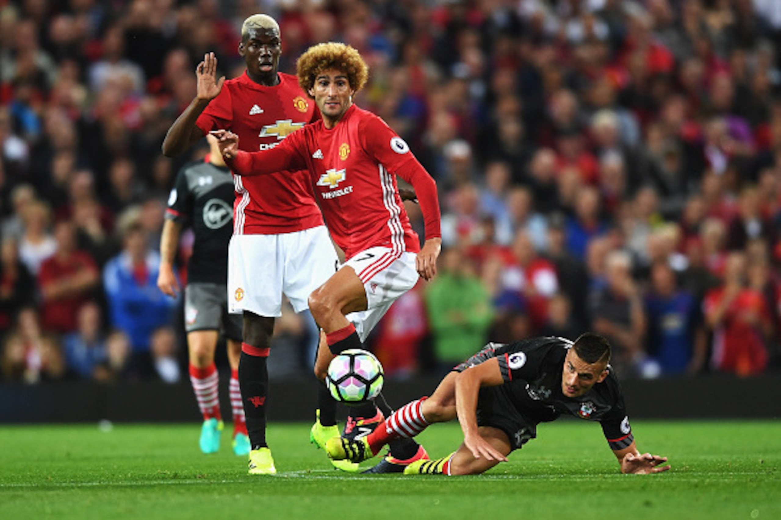 MANCHESTER, ENGLAND - AUGUST 19: Marouane Fellaini and Paul Pogba of Manchester United challenge for the ball with Dusan Tadic of Southampton during the Premier League match between Manchester United and Southampton at Old Trafford on August 19, 2016 in M MANCHESTER, ENGLAND - AUGUST 19: Marouane Fellaini and Paul Pogba of Manchester United challenge for the ball with Dusan Tadic of Southampton during the Premier League match between Manchester United and Southampton at Old Trafford on August 19, 2016 in M
