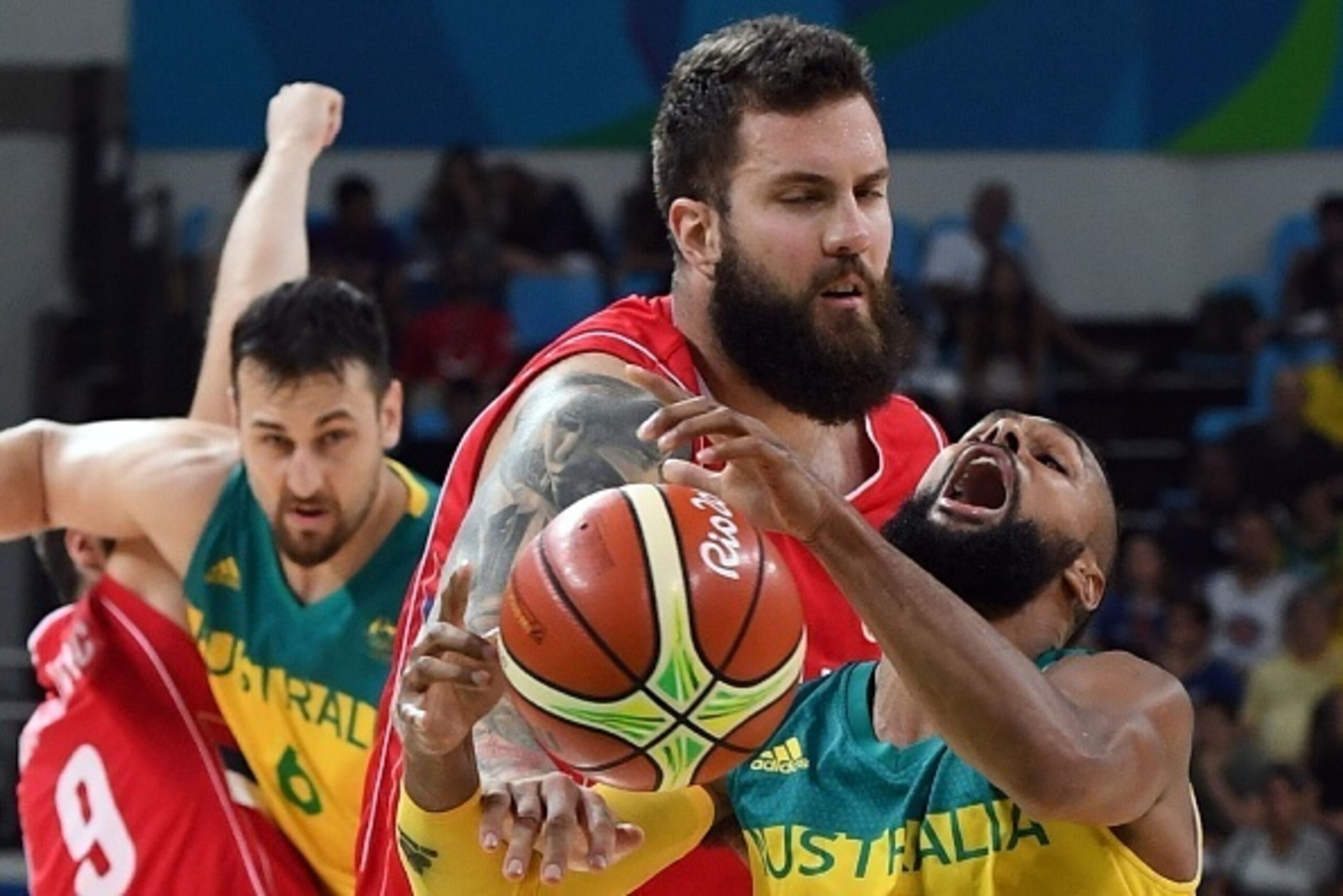 Serbia's centre Miroslav Raduljica (C) fouls Australia's guard Patty Mills (R) during a Men's semifinal basketball match between Australia and Serbia at the Carioca Arena 1 in Rio de Janeiro on August 19, 2016 during the Rio 2016 Olympic Games. / AFP / Ma