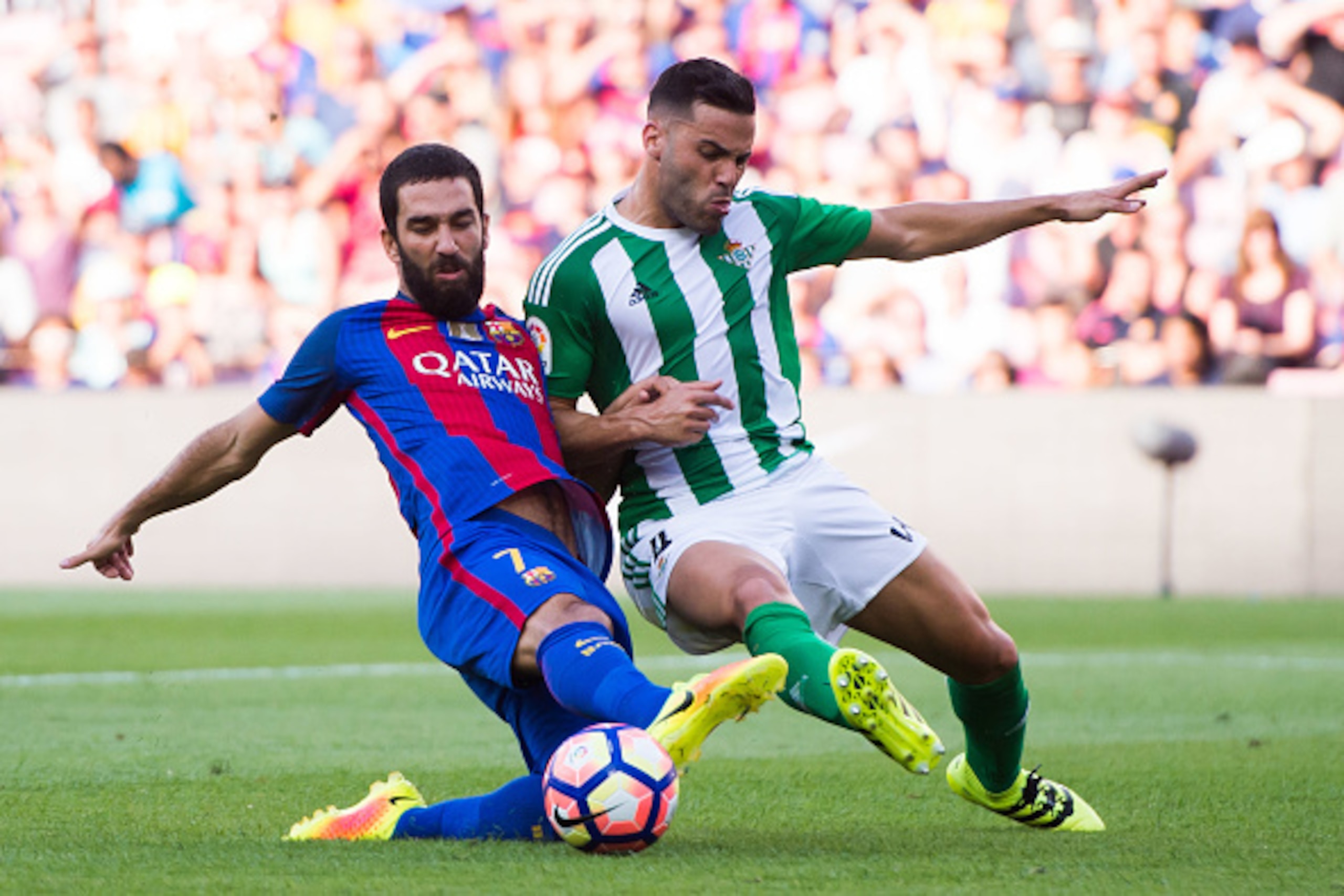 BARCELONA, SPAIN - AUGUST 20: Arda Turan (L) of FC Barcelona fights for the ball with Bruno Gonzalez of Real Betis Balompie during the La Liga match between FC Barcelona and Real Betis Balompie at Camp Nou on August 20, 2016 in Barcelona, Spain. (Photo by