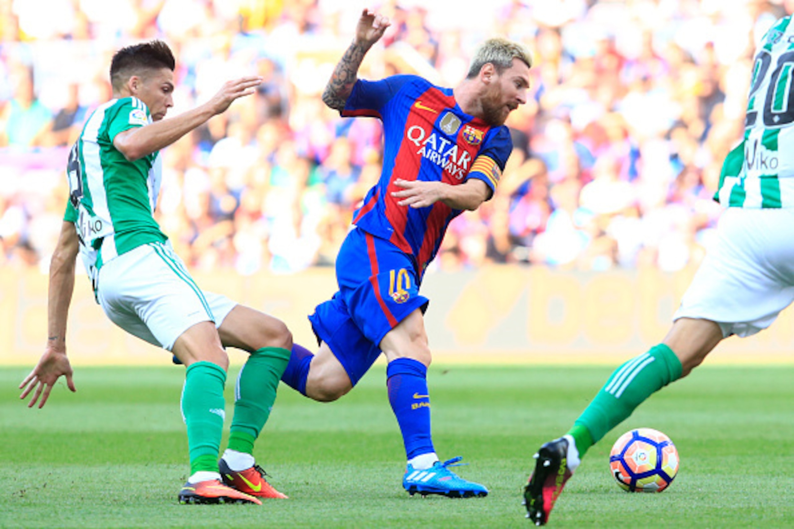 Barcelona's Argentinian forward Lionel Messi (C) vies with Betis' French midfielder Jonas Martin during the Spanish league football match FC Barcelona vs Real Betis Balompie at the Camp Nou stadium in Barcelona on August 20, 2016. / AFP / PAU BARRENA     