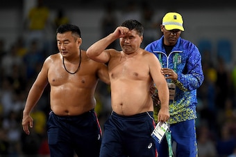 RIO DE JANEIRO, BRAZIL - AUGUST 21:  Mongolias coaches protest the judges decision after Mandakhnaran Ganzorig (red) of Mongolia is defeated by Ikhtiyor Navruzov (blue) of Uzbekistan in the Men's Freestyle 65kg Bronze match against  on Day 16 of the Rio 2