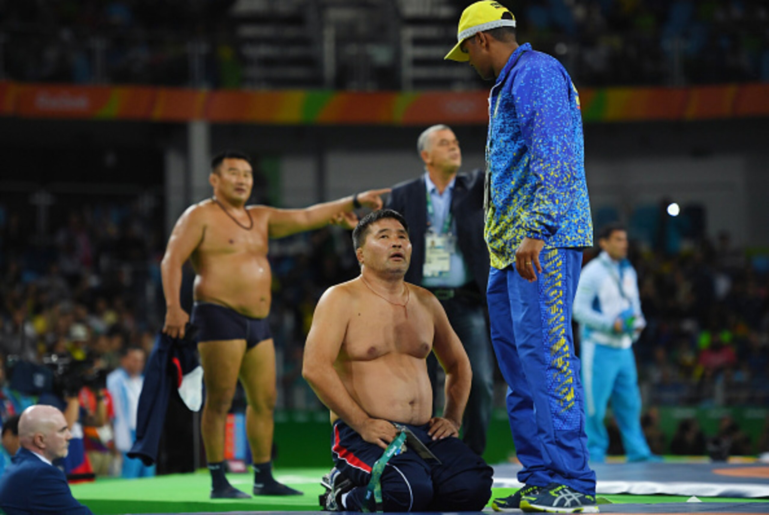 RIO DE JANEIRO, BRAZIL - AUGUST 21:  Mongolias coaches protest the judges decision after Mandakhnaran Ganzorig (red) of Mongolia is defeated by Ikhtiyor Navruzov (blue) of Uzbekistan in the Men's Freestyle 65kg Bronze match against  on Day 16 of the Rio 2