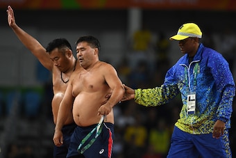 RIO DE JANEIRO, BRAZIL - AUGUST 21:  Mongolias coaches protest the judges decision after Mandakhnaran Ganzorig (red) of Mongolia is defeated by Ikhtiyor Navruzov (blue) of Uzbekistan in the Men's Freestyle 65kg Bronze match against  on Day 16 of the Rio 2
