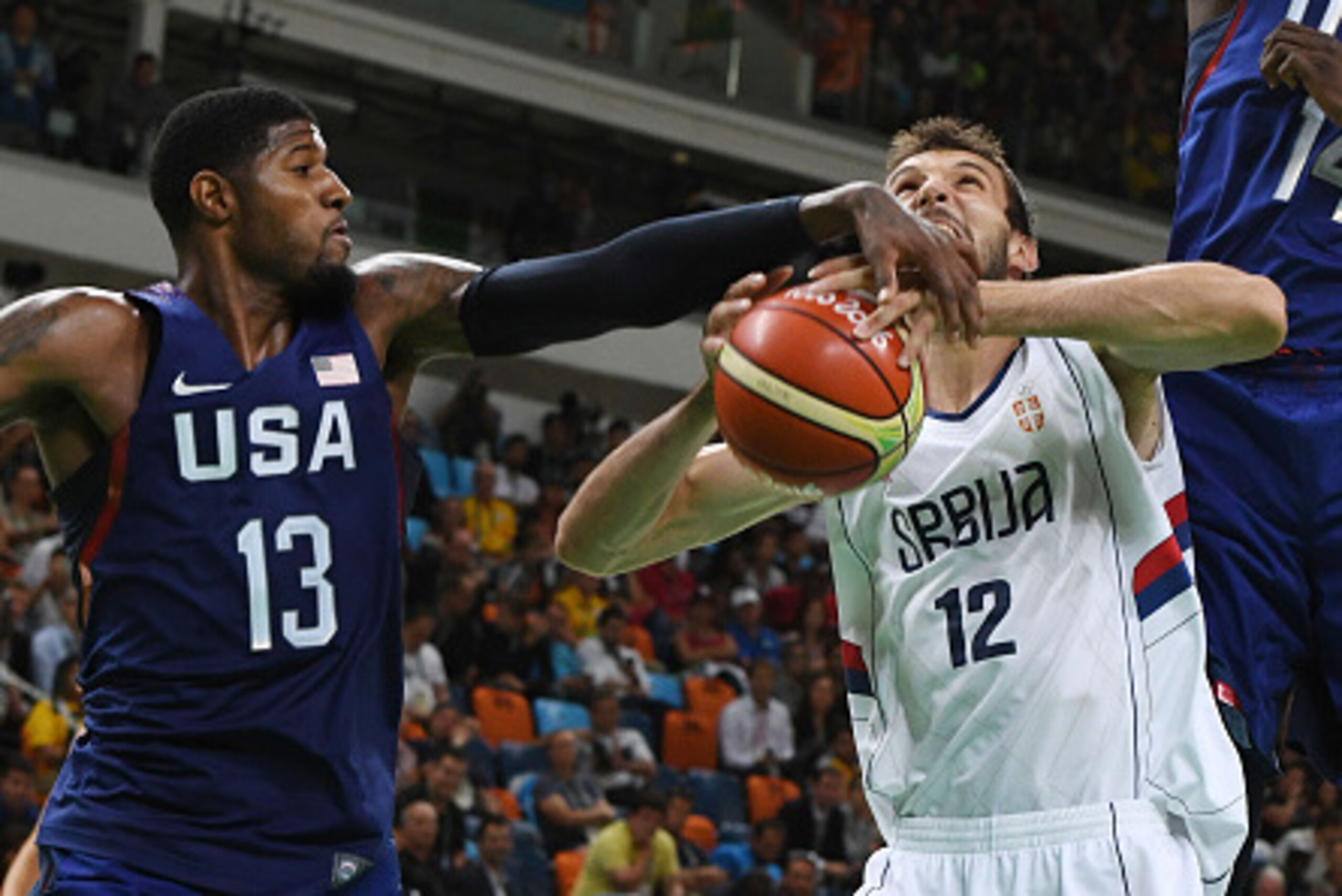 Serbia's power forward Stefan Bircevic (C) is blocked by USA's guard Paul George (L) during a Men's Gold medal basketball match between Serbia and USA at the Carioca Arena 1 in Rio de Janeiro on August 21, 2016 during the Rio 2016 Olympic Games. / AFP / M