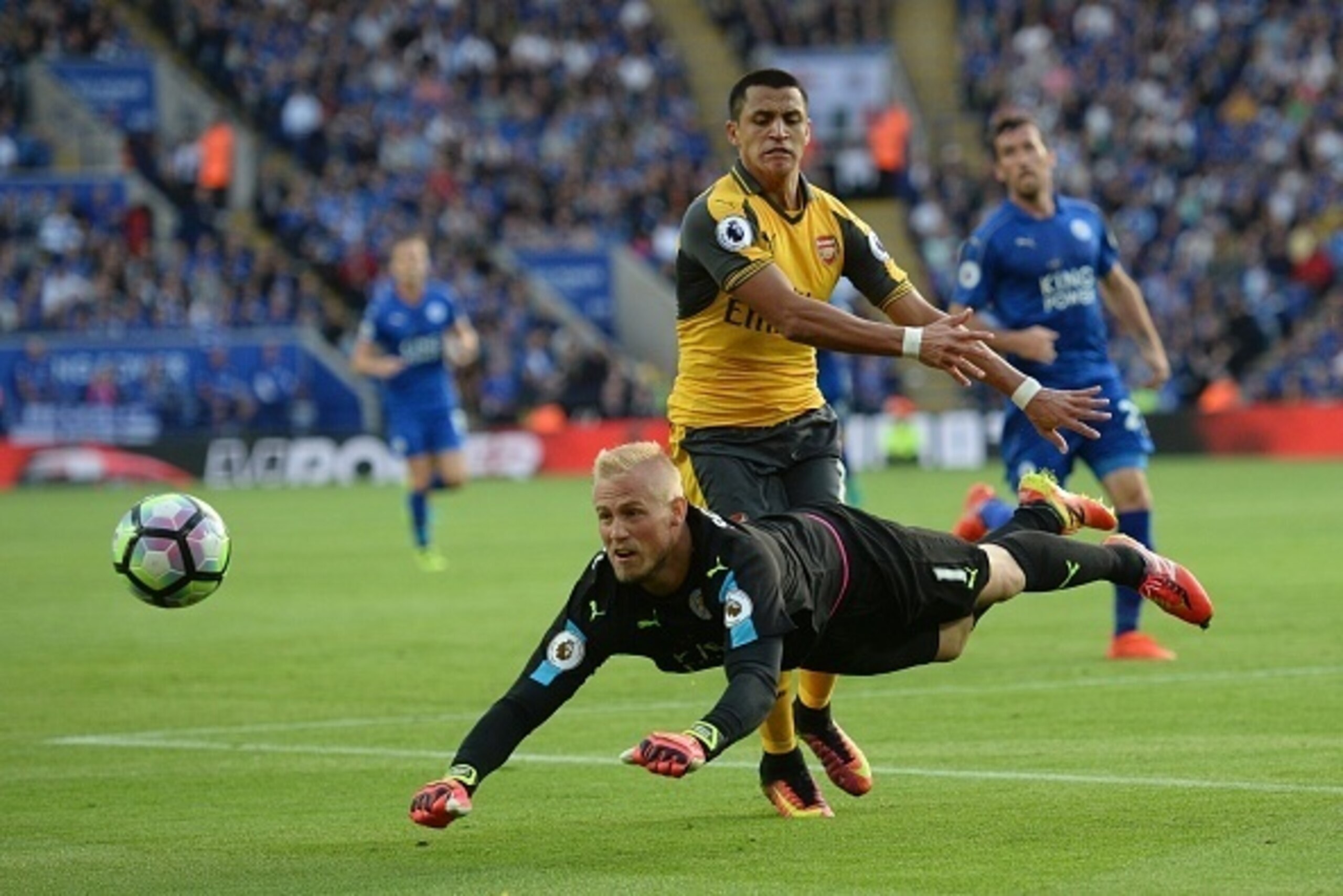 Leicester City's Danish goalkeeper Kasper Schmeichel (L) heads the ball away from Arsenal's Chilean striker Alexis Sanchez (R) during the English Premier League football match between Leicester City and Arsenal at King Power Stadium in Leicester, central 