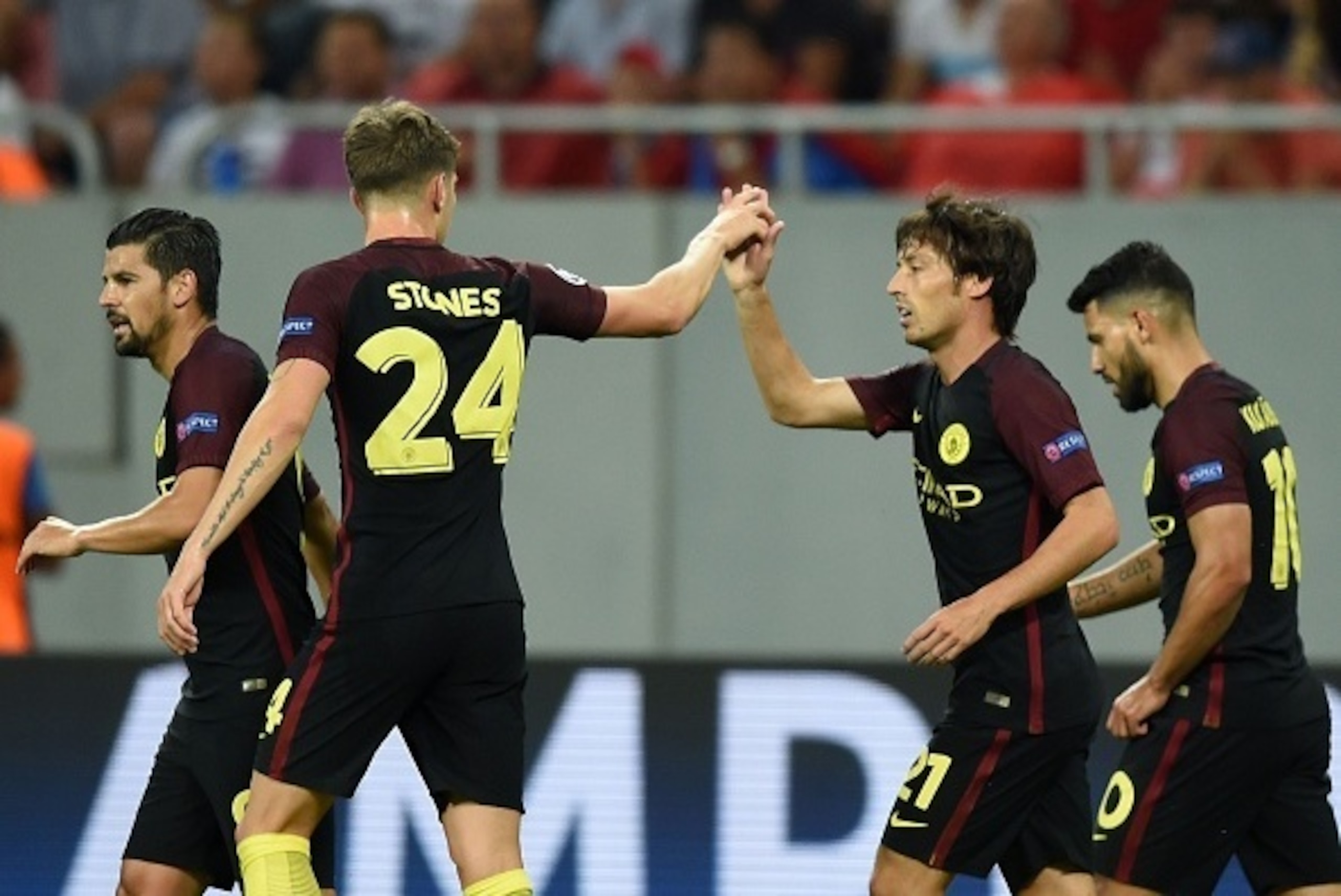David Silva (2R) of Manchester City celebrates a goal with Manchester City's English defender John Stones (2L) during the UEFA Champions league first leg play-off football match between against Steaua Bucharest and Manchester City at the National Arena st