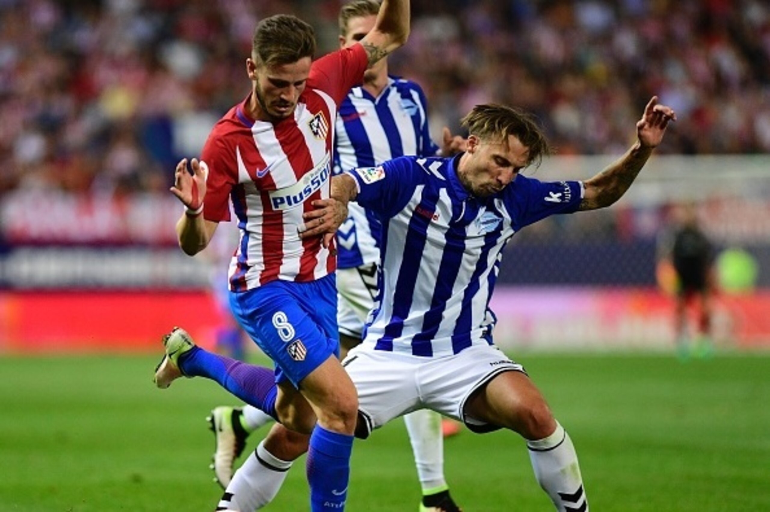 Atletico Madrid's midfielder Saul Niguez (L) vies with Deportivo Alaves' defender Alexis during the Spanish league football match Club Atletico de Madrid vs Deportivo Alaves at the Vicente Calderon stadium in Madrid on Ausgut 21, 2016. / AFP / PIERRE-PHIL