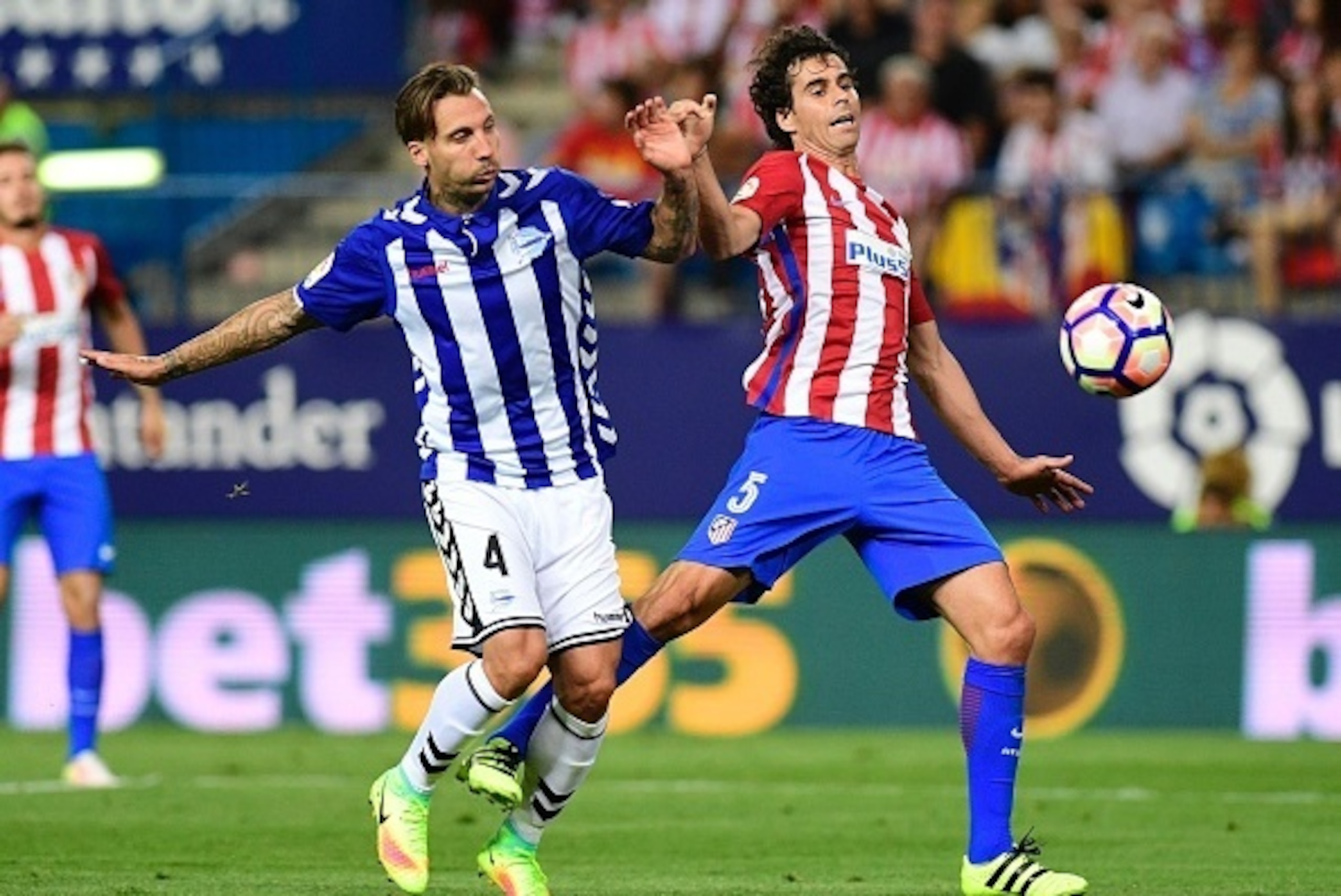 Atletico Madrid's Portuguese midfielder Tiago (R) vies with Deportivo Alaves' defender Alexis during the Spanish league football match Club Atletico de Madrid vs Deportivo Alaves at the Vicente Calderon stadium in Madrid on Ausgut 21, 2016. / AFP / PIERRE
