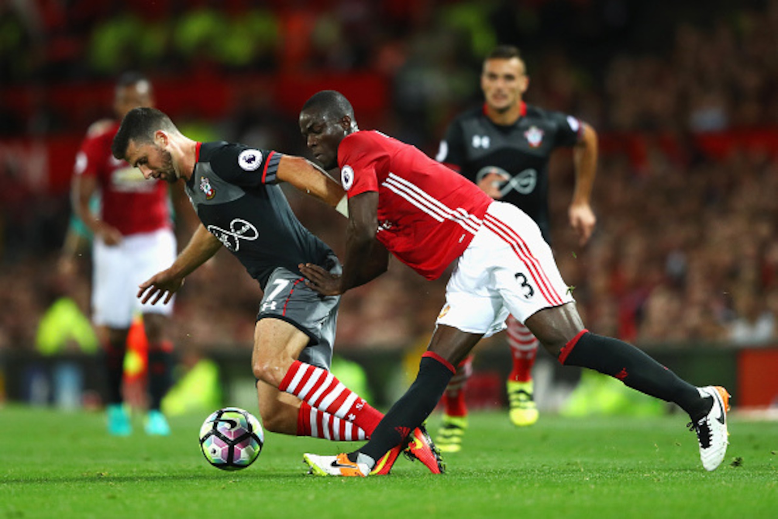 MANCHESTER, ENGLAND - AUGUST 19: Eric Bailly of Manchester United tackles Shane Long of Southampton during the Premier League match between Manchester United and Southampton at Old Trafford on August 19, 2016 in Manchester, England.  (Photo by Michael Ste
