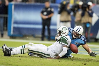 NASHVILLE, TN - SEPTEMBER 29:  Geno Smith #7 of the New York Jets tries to get away from Karl Klug #97 of the Tennessee Titans and fumbles the football at LP Field on September 29, 2013 in Nashville, Tennessee.  The Titans defeated the Jets 38-13.  (Photo