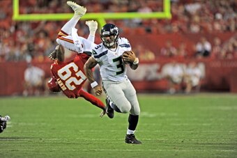 KANSAS CITY, MO - AUGUST 24:  Quarterback Russell Wilson #3 of the Seattle Seahawks rushes around the end for a first down, as safety Eric Berry #29 of the Kansas City Chiefs gets blocked into the air during the first half of a preseason game on August 24