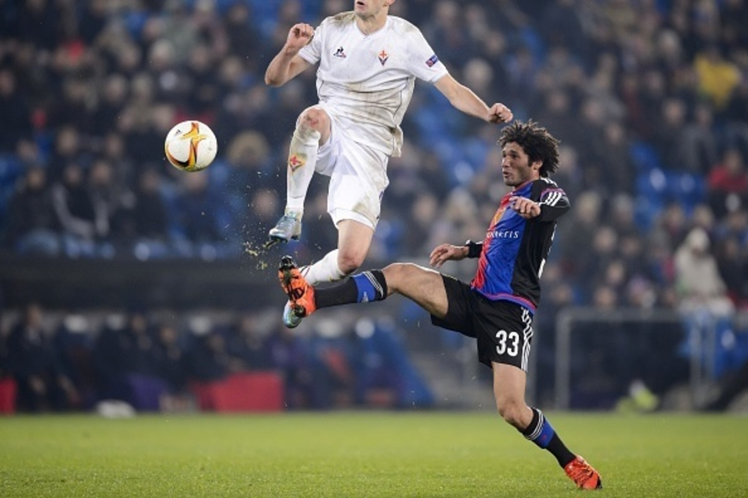 Fiorentina's Croatian forward Nikola Kalinic (L) challenges Basel's Egyptian midfielder Mohamed Elneny during the UEFA Europa League group I football match between Basel and Fiorentina at the St Jakob stadium in Basel on November 26, 2015.   / AFP / FABRI