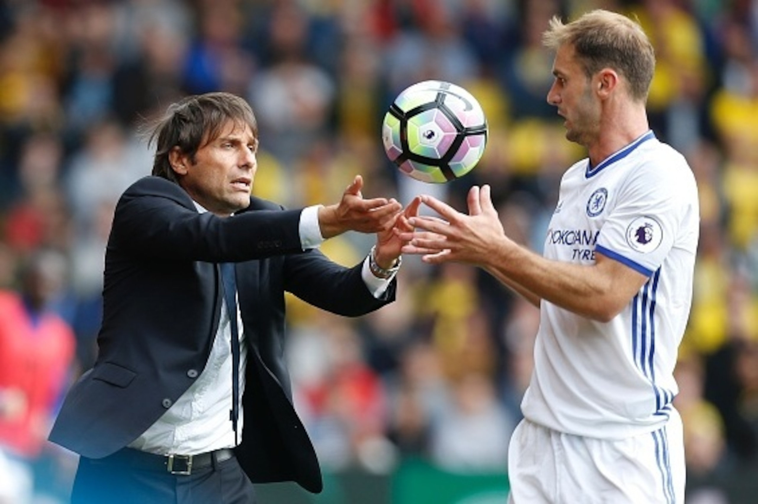 Chelsea's Italian head coach Antonio Conte (L) passes the ball to Chelsea's Serbian defender Branislav Ivanovic (R) during the English Premier League football match between Watford and Chelsea at Vicarage Road Stadium in Watford, north of London on August