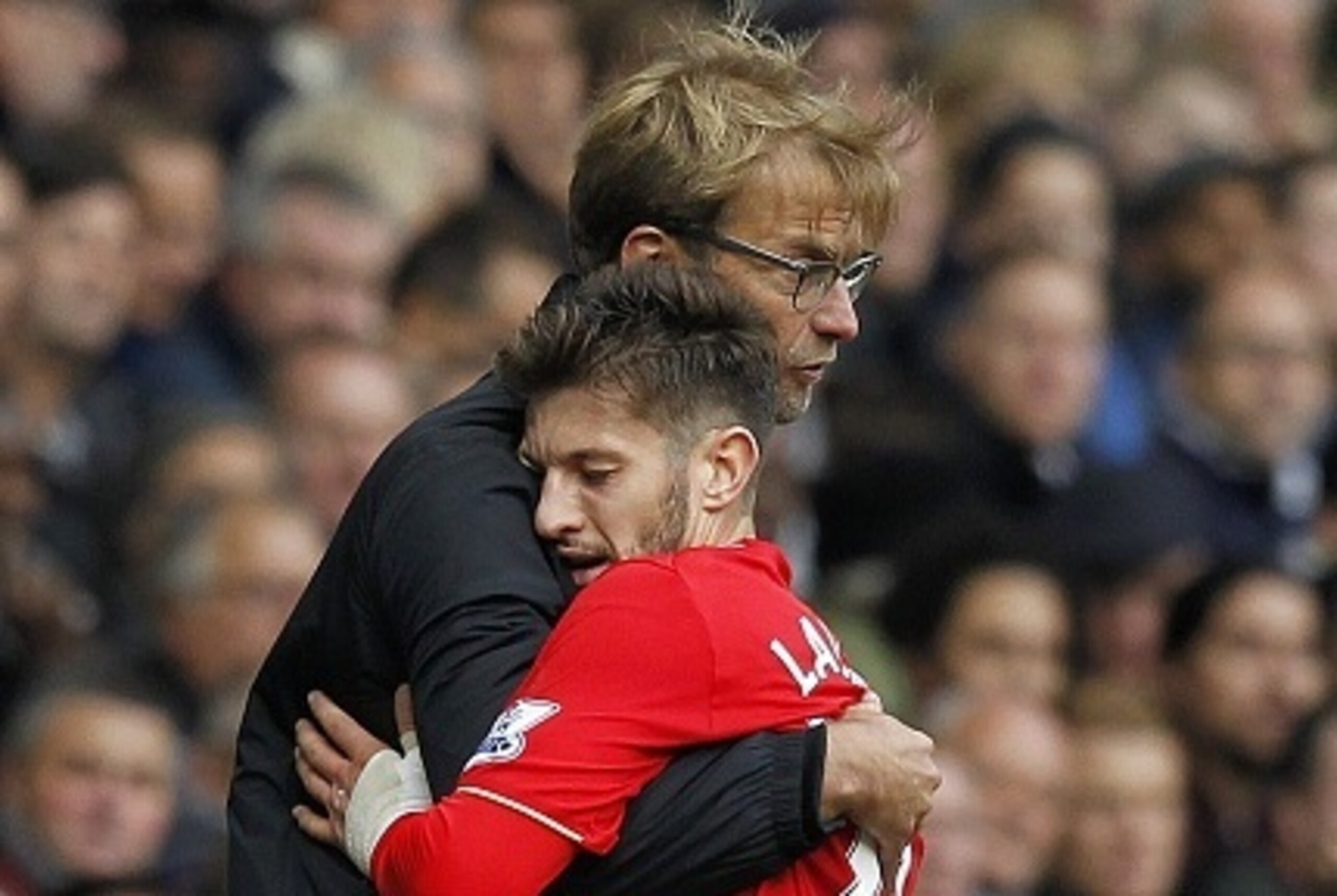 Liverpool's German manager Jurgen Klopp embraces Liverpool's English midfielder Adam Lallana (R) as he is substituted during the English Premier League football match between Tottenham Hotspur and Liverpool at White Hart Lane in north London on October 17
