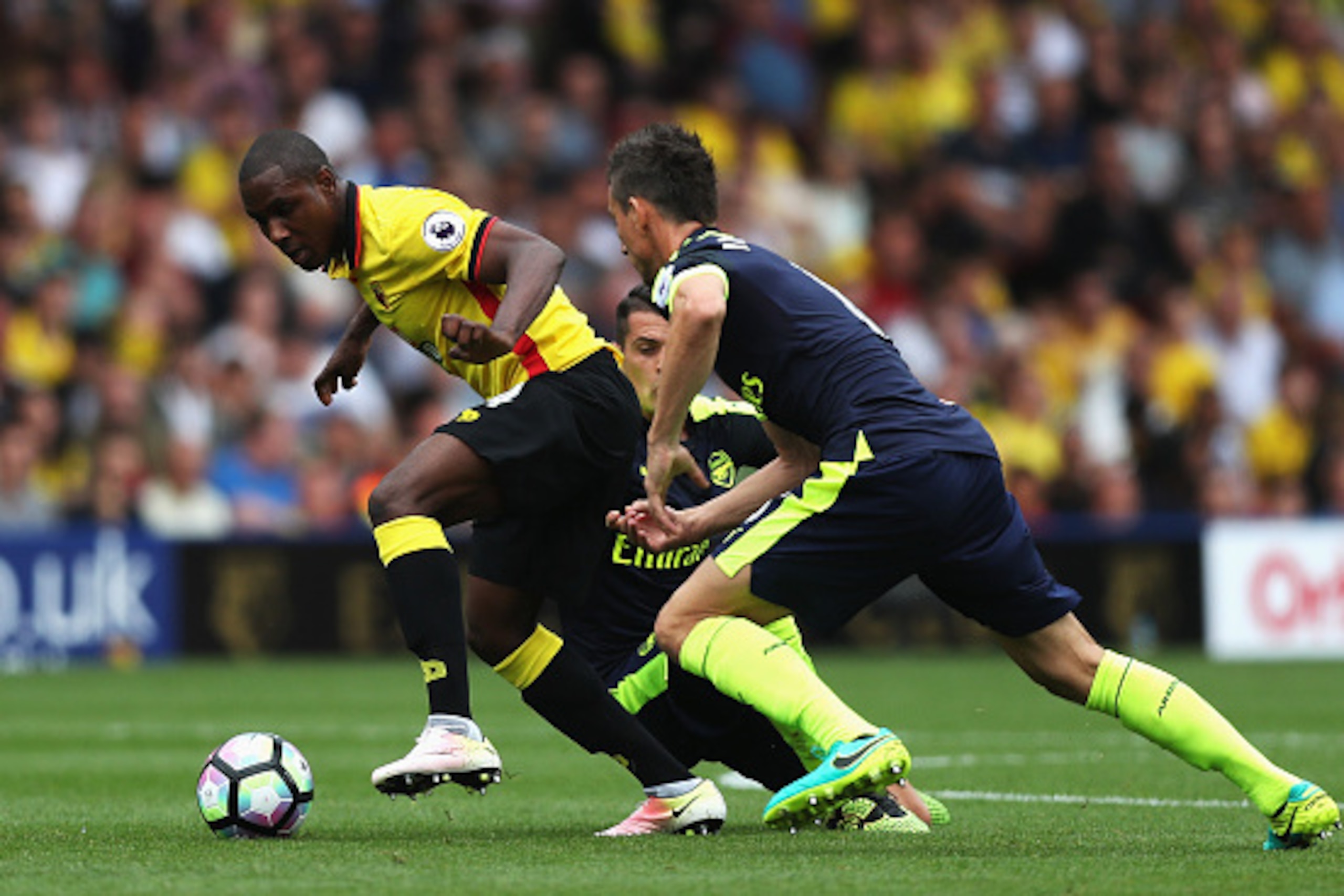WATFORD, ENGLAND - AUGUST 27: Odion Ighalo of Watford takes the ball past Laurent Koscielny of Arsenal during the Premier League match between Watford and Arsenal at Vicarage Road on August 27, 2016 in Watford, England.  (Photo by Christopher Lee/Getty Im