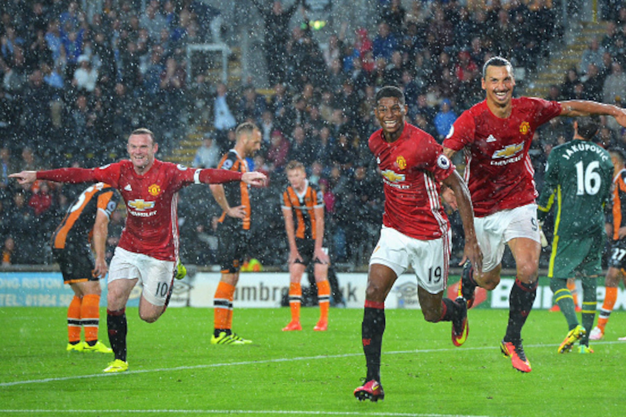 HULL, ENGLAND - AUGUST 27: Marcus Rashford of Manchester United (C) celebrates scoring his sides first goal with his team mates Wayne Rooney of Manchester United (L) and Zlatan Ibrahimovic of Manchester United (R) during the Premier League match between H