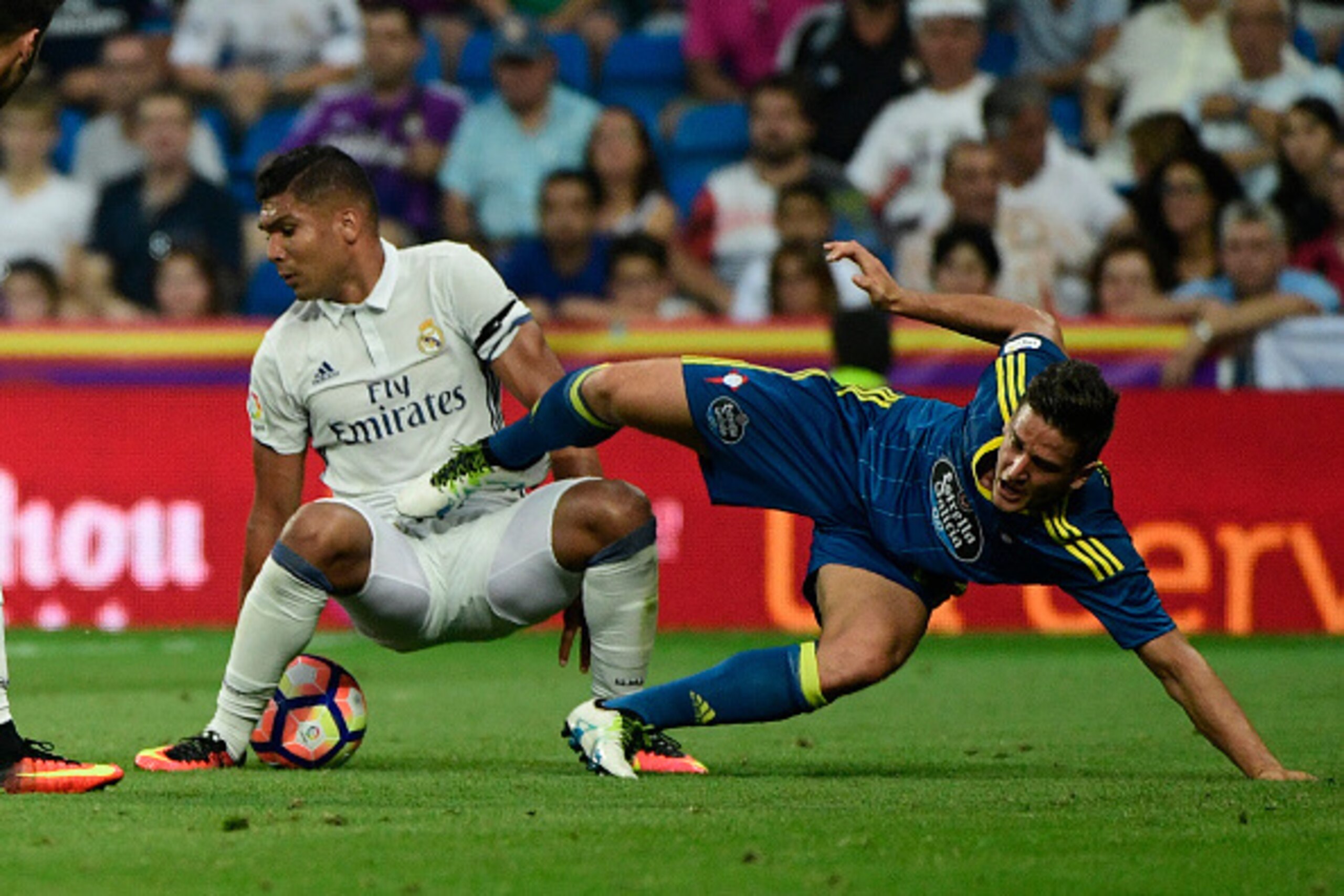 Real Madrid's Brazilian midfielder Casemiro (L) vies with Celta Vigo's Chilean forward Fabian Orellana during the Spanish league football match Real Madrid CF vs RC Celta de Vigo at the Santiago Bernabeu stadium in Madrid on August 27, 2016. / AFP / PIERR