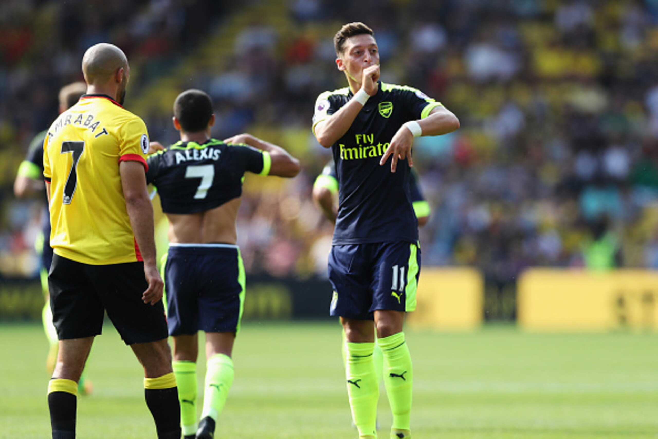 WATFORD, ENGLAND - AUGUST 27: (R) Mesut Ozil of Arsenal gesutres to the Arsenal fans during the Premier League match between Watford and Arsenal at Vicarage Road on August 27, 2016 in Watford, England.  (Photo by Christopher Lee/Getty Images)