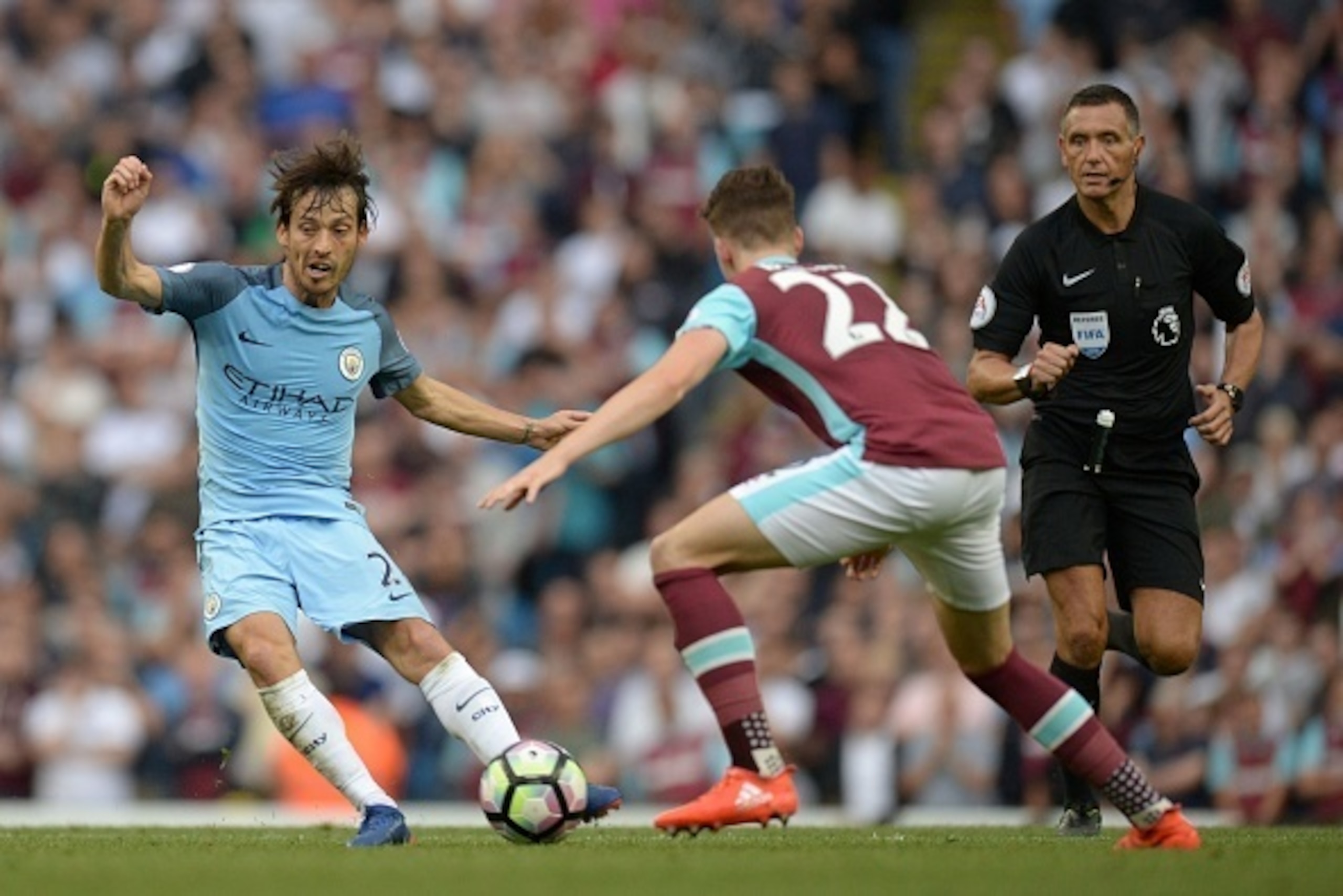 Manchester City's Spanish midfielder David Silva (L) passes the ball past West Ham United's English defender Sam Byram during the English Premier League football match between Manchester City and West Ham United at the Etihad Stadium in Manchester, north 