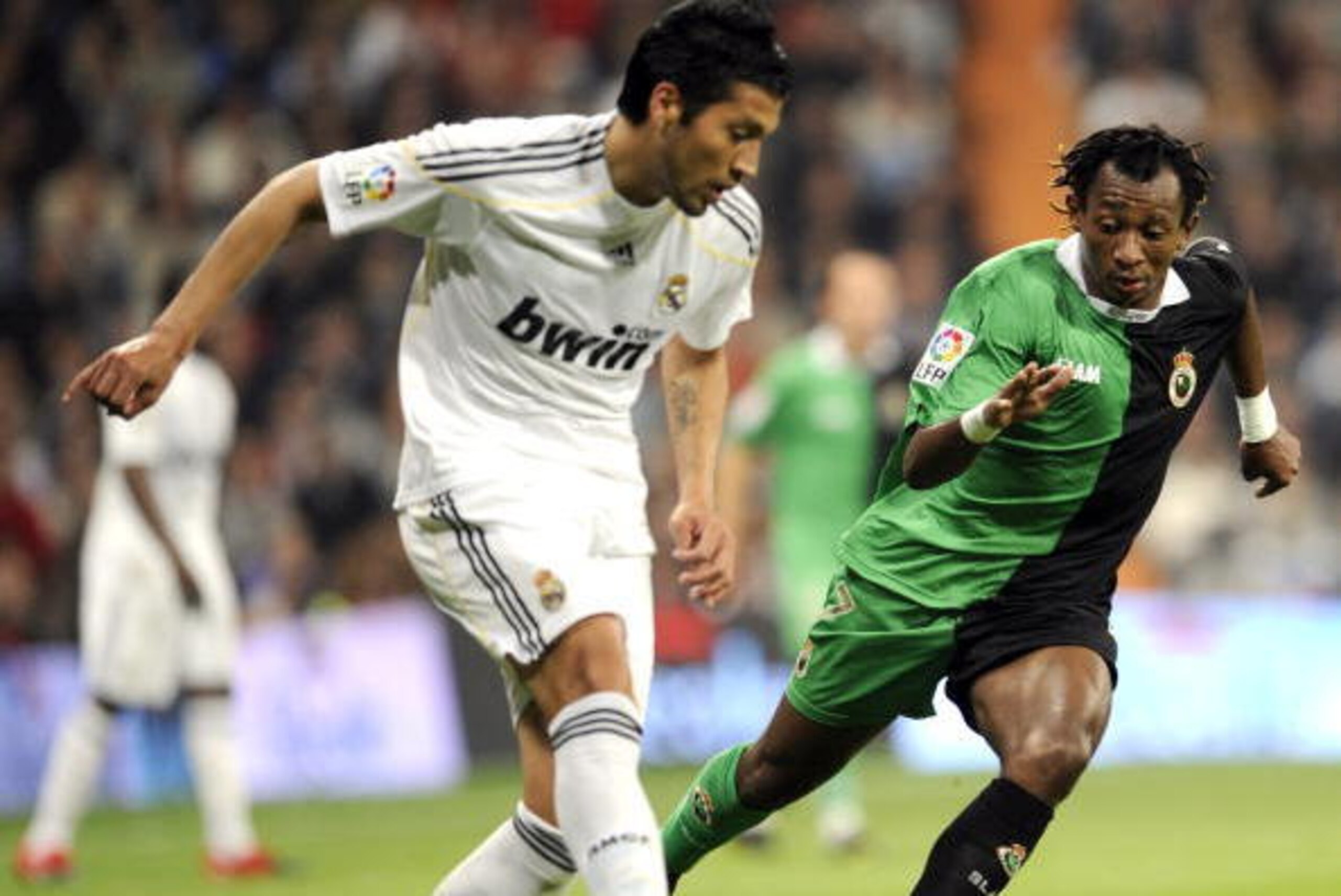 Real Madrid's Argentinian defender Ezequiel Garay (L) vies for the ball with Racing Santander's Burundian forward Mohammed Tchite (R) during Spanish league football match Real Madrid against Racing Santander at the Santiago Bernabeu stadium in Madrid, on 